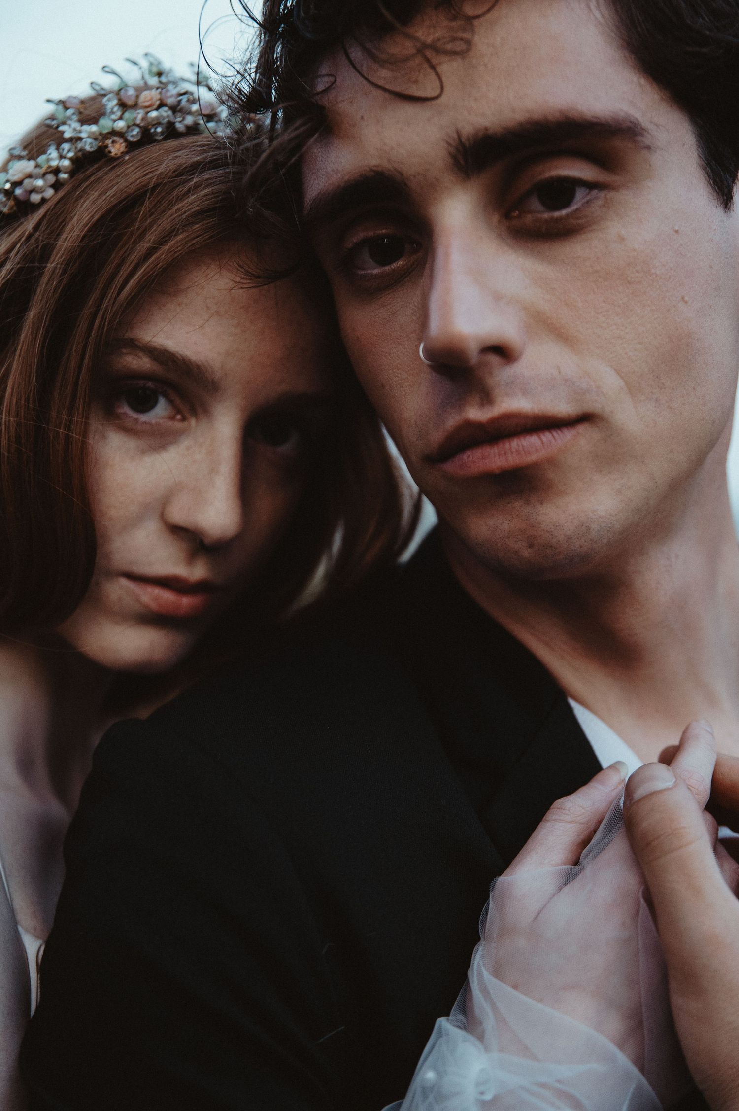 Moody close-up portrait of a couple with the bride wearing a crystal headpiece.