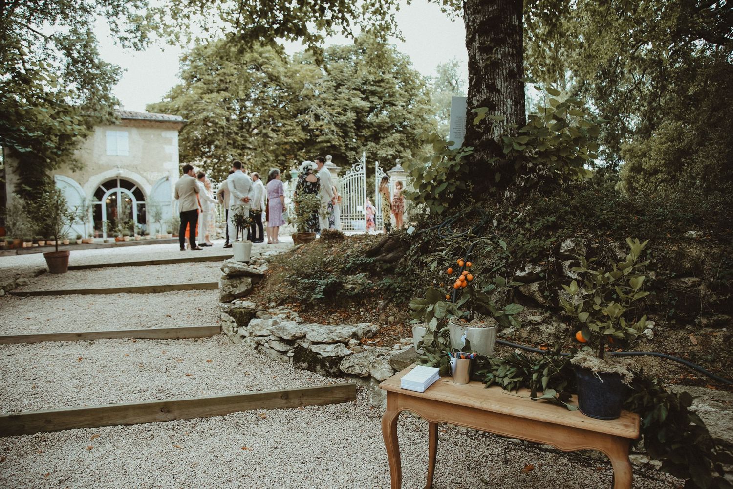 Rustic outdoor wedding venue with stone walls and wooden bench in foreground.