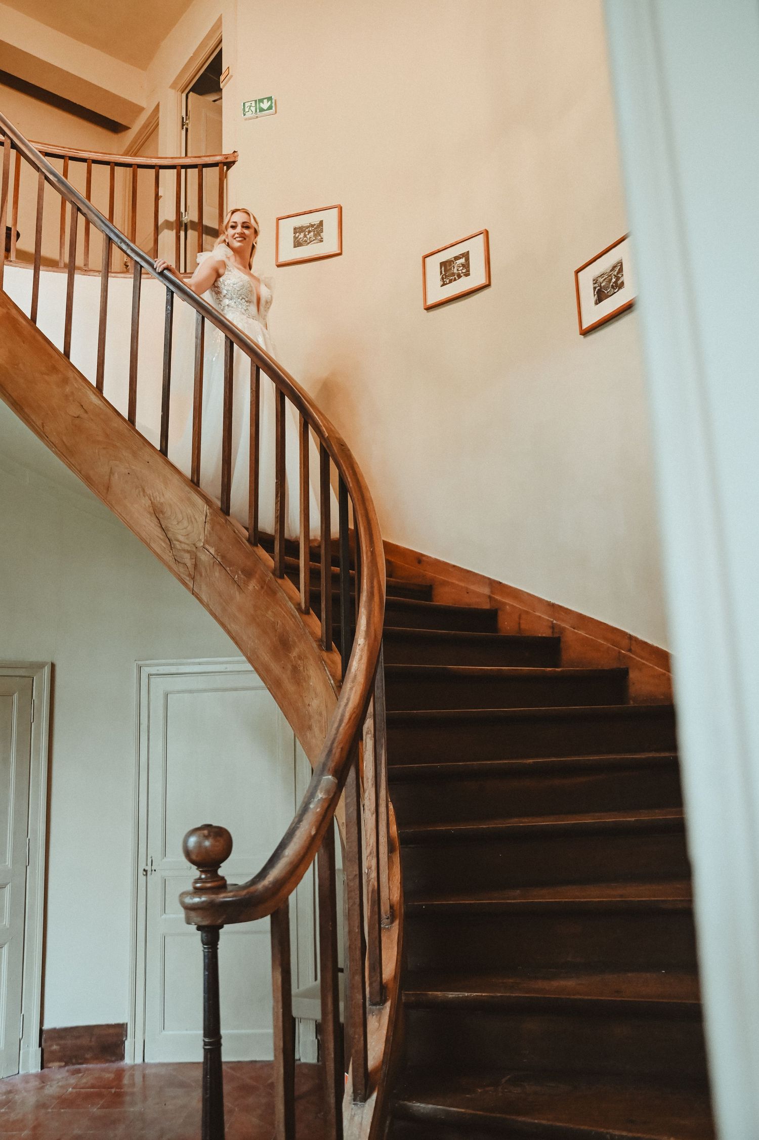 Elegant curved wooden staircase in a vintage building interior.