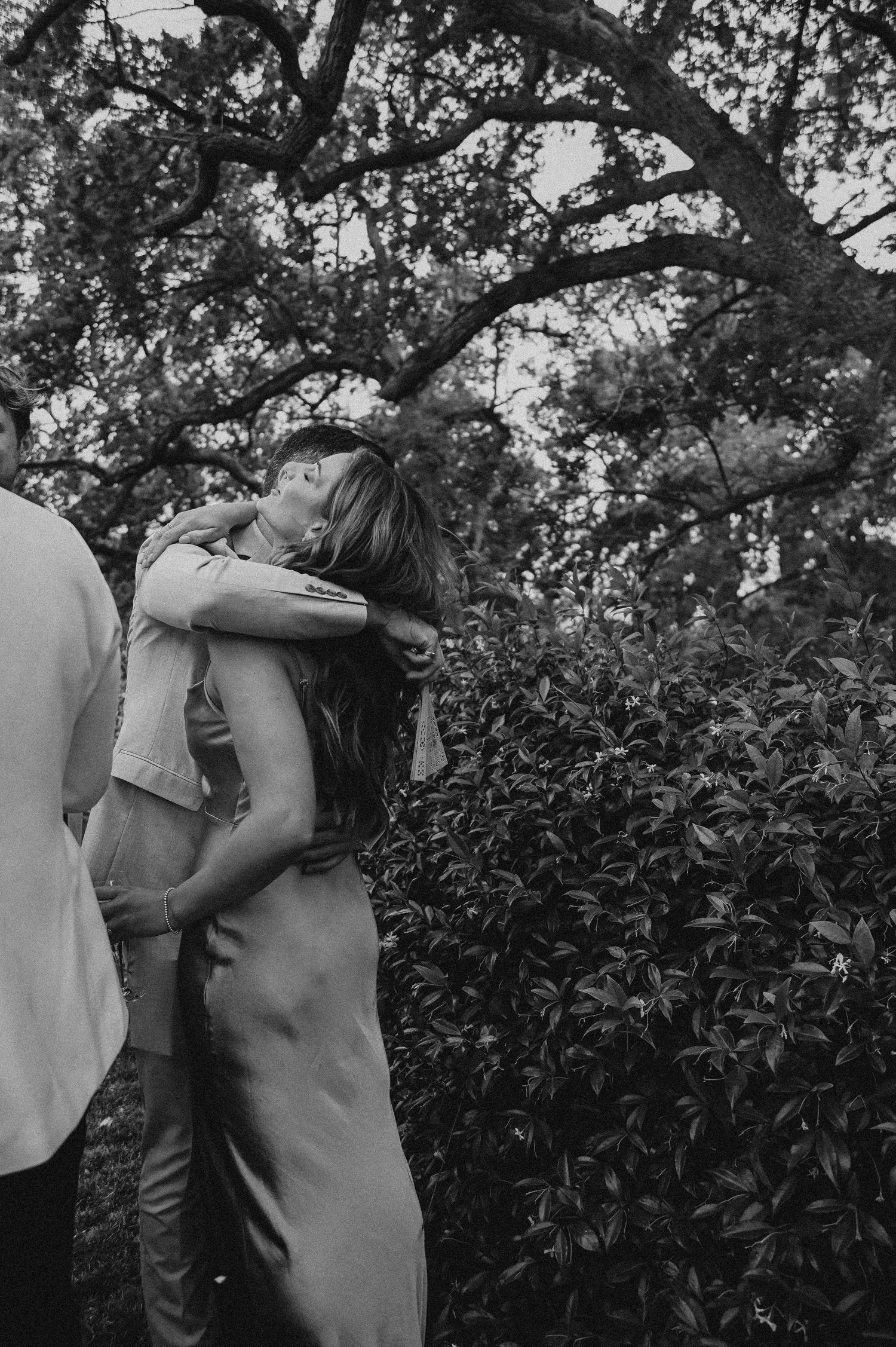 A couple shares an intimate moment in a garden setting during their wedding day.