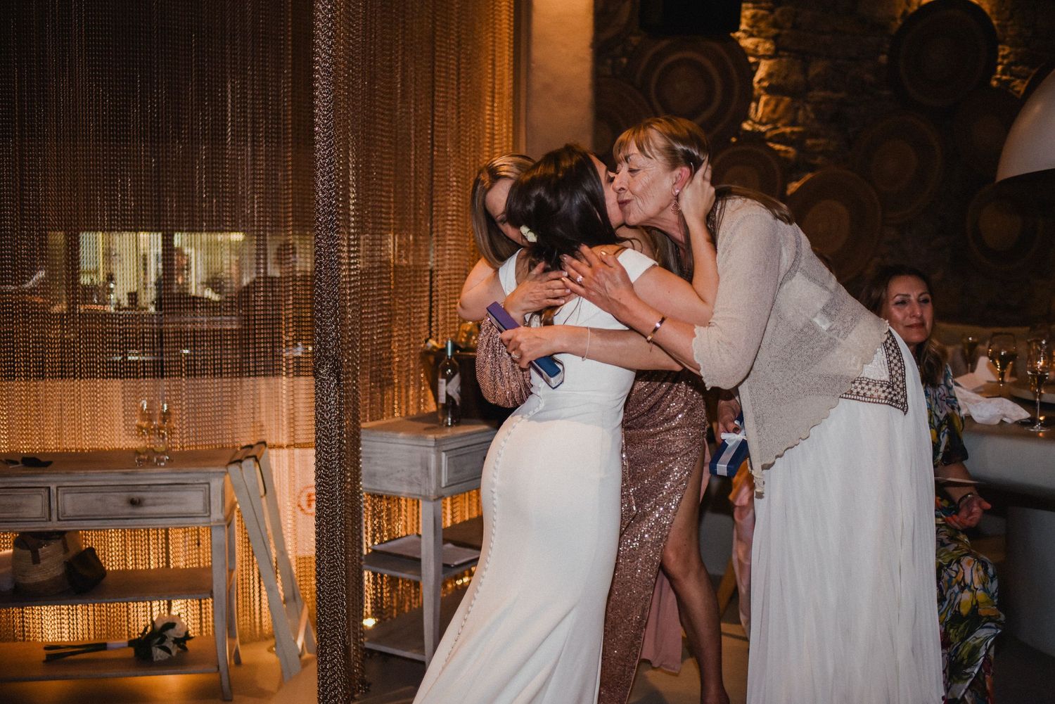 Guests share an emotional moment during a celebration in an elegantly decorated venue.