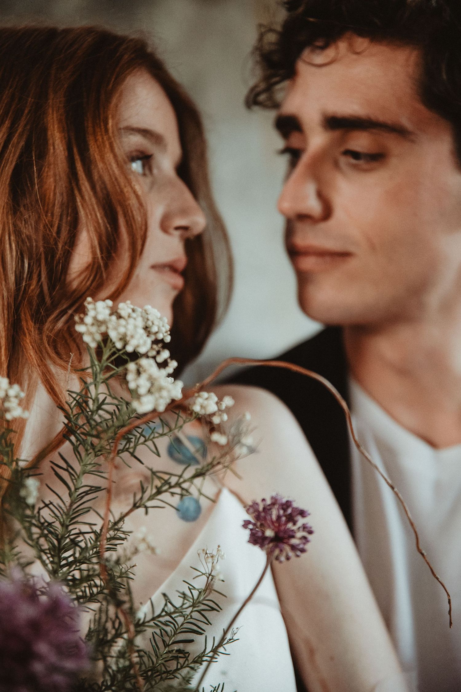 Artistic portrait capturing tender moment with florals and natural lighting.