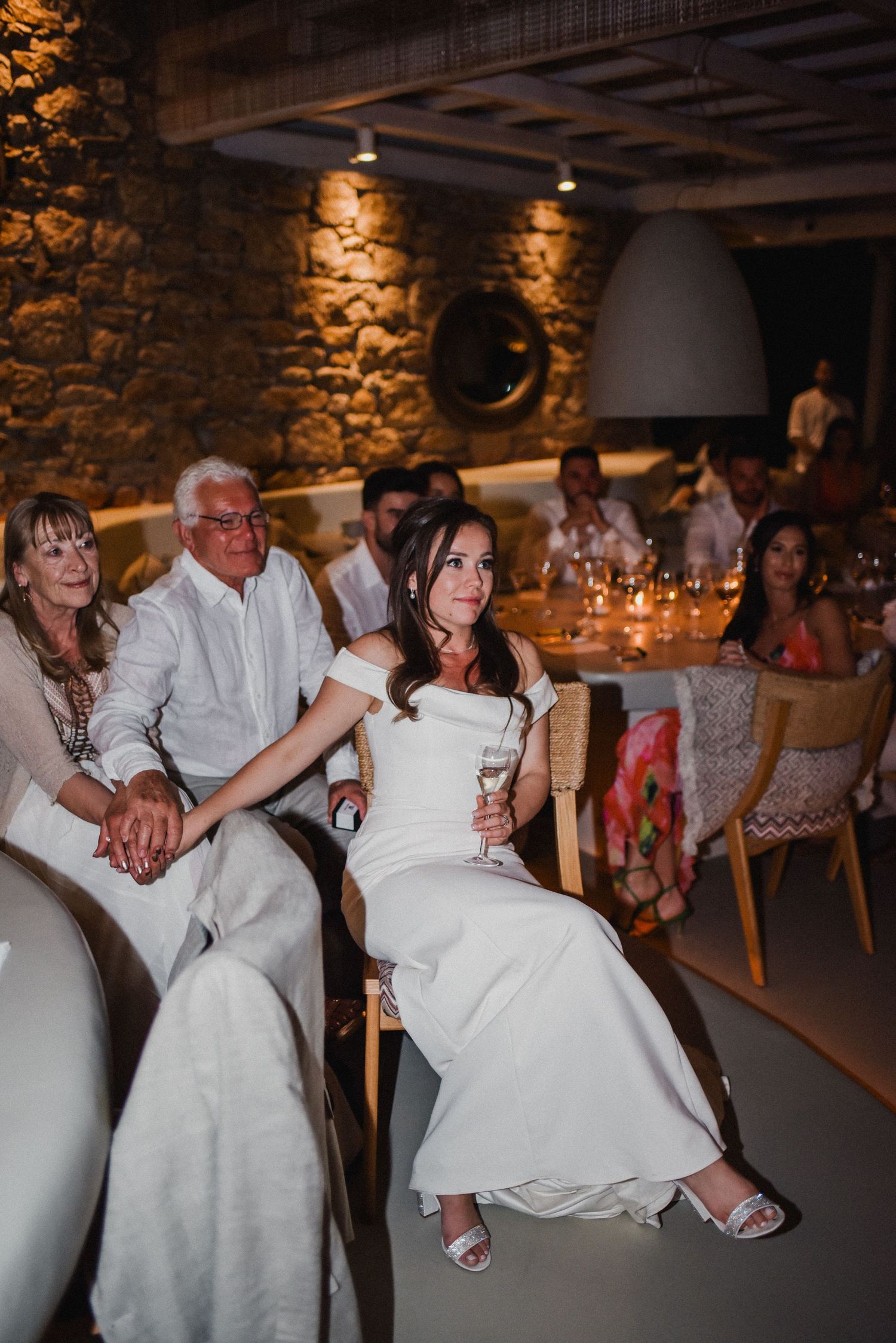 Wedding reception in rustic stone venue with warm ambient lighting.