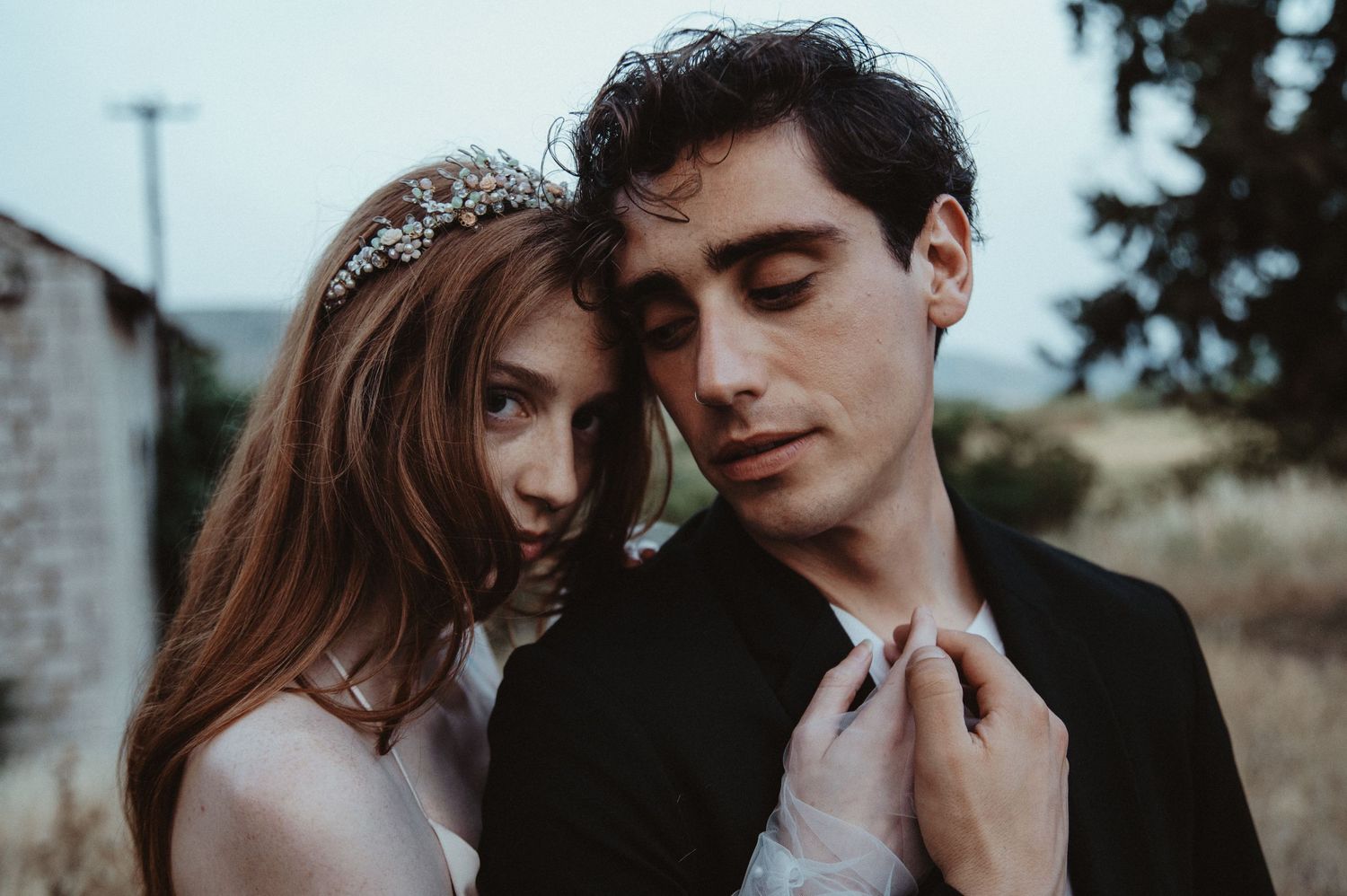 Artistic wedding photo capturing a tender moment between newlyweds in natural lighting.