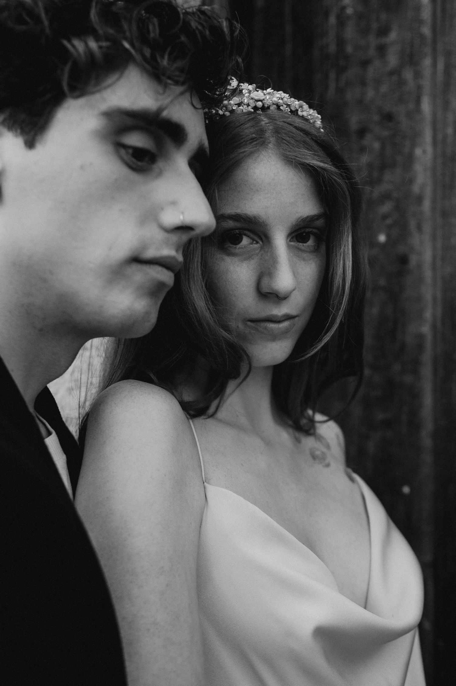 Dramatic black and white close-up of newlyweds in classic formal wear.