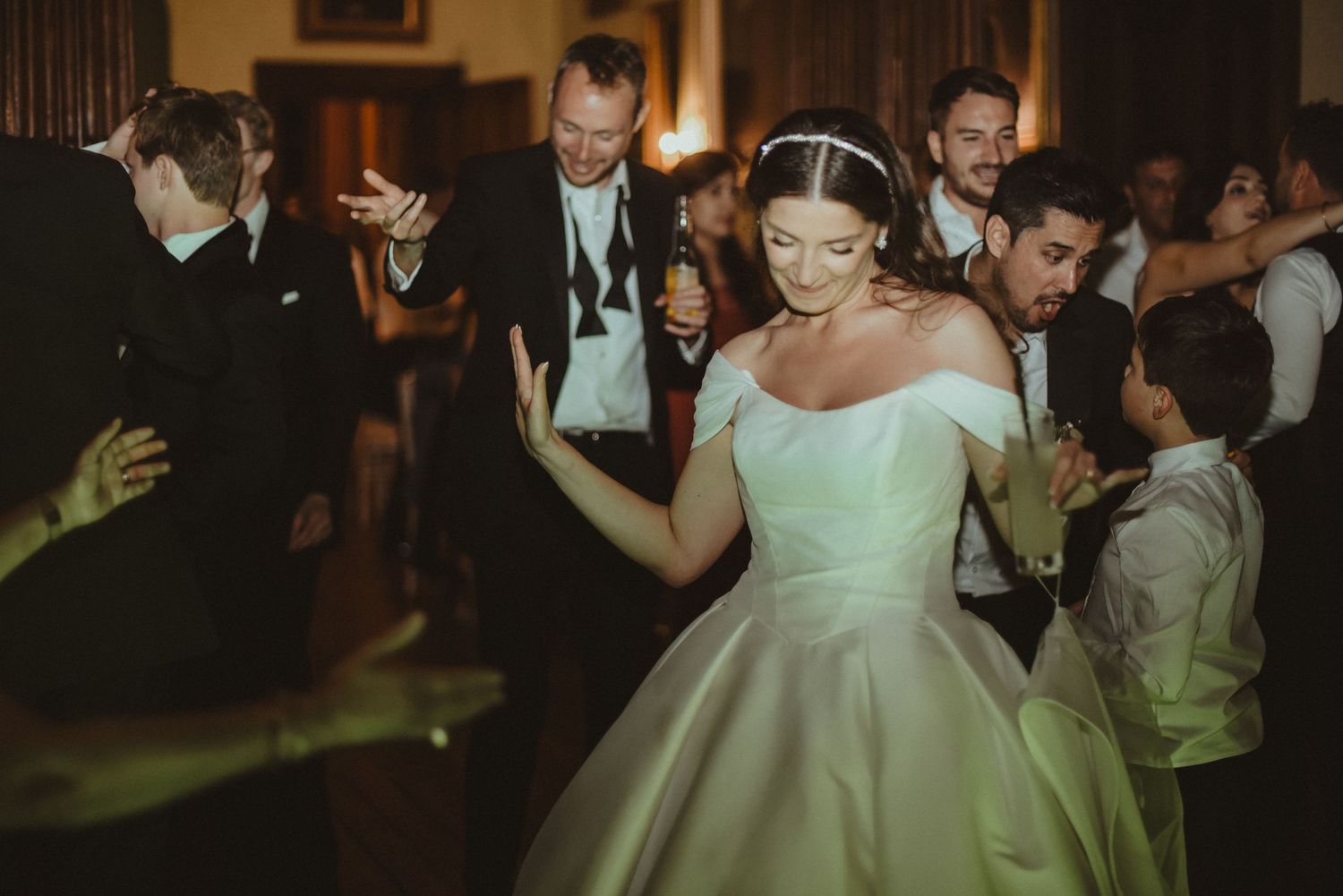 Wedding guests dancing and celebrating during an elegant indoor reception.