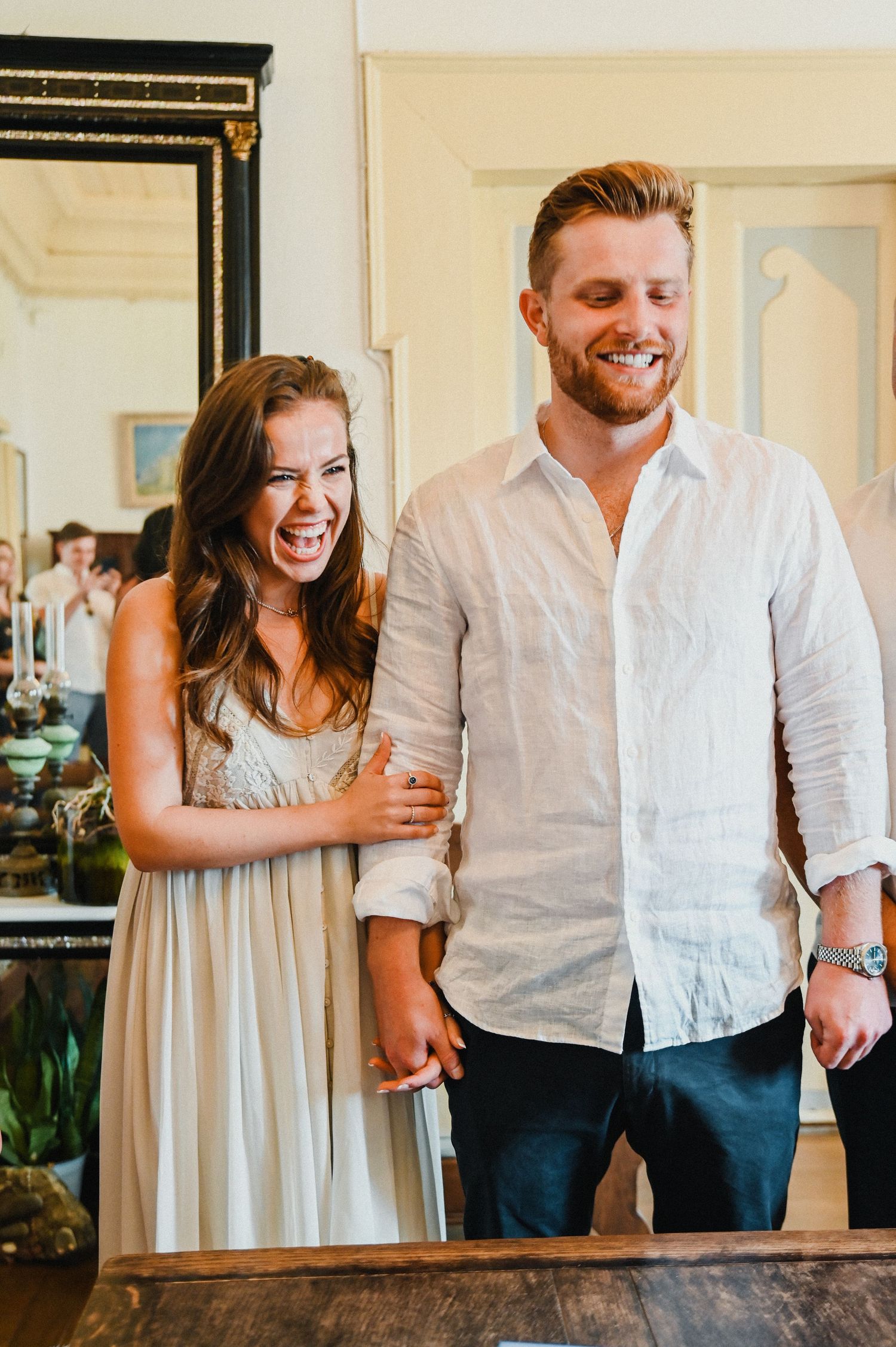 A candid moment showing a couple laughing together indoors.