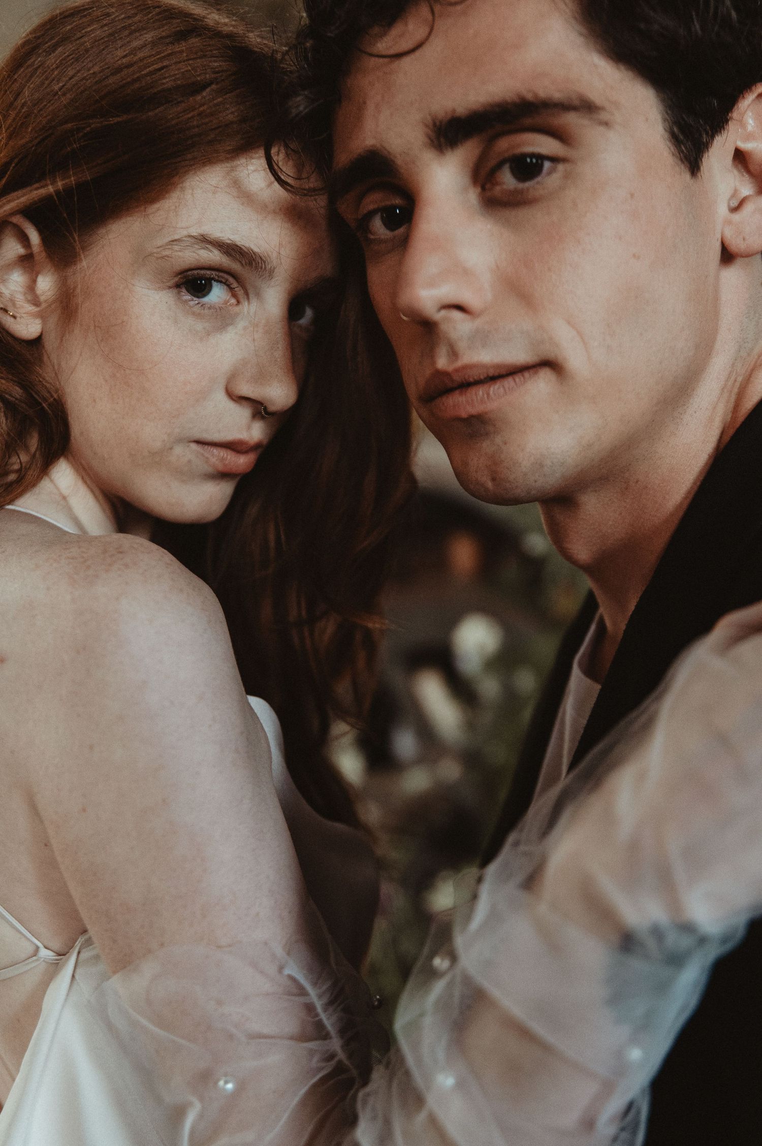 Close up portrait of a couple in romantic wedding attire with vintage-inspired styling.
