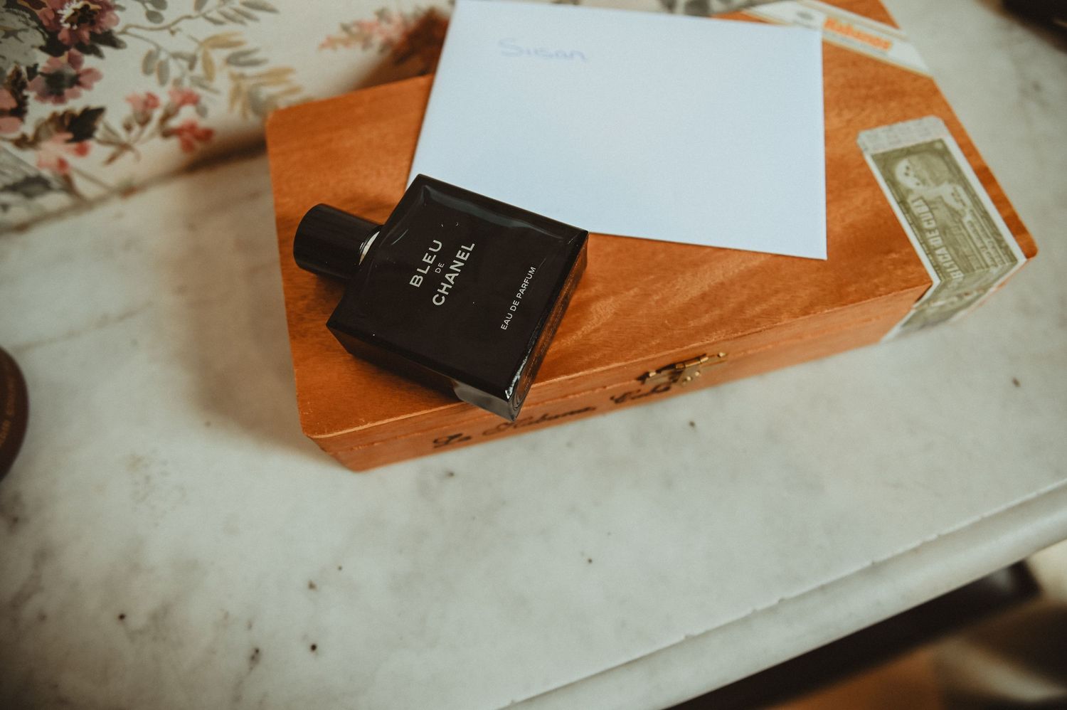 A black book and white paper on a wooden box with vintage styling.