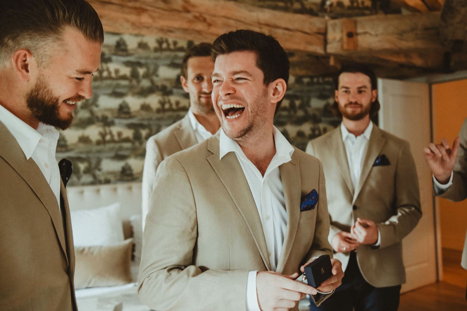A joyful moment shared between people in formal attire against a rustic brick wall background.