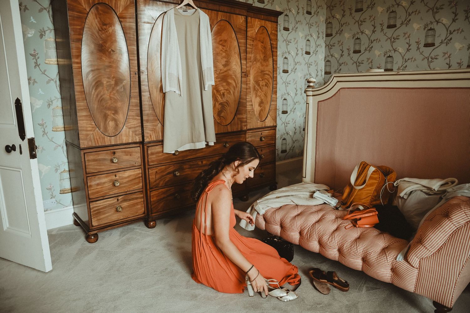 Bridal preparation room with antique furniture and coral-colored decor elements.