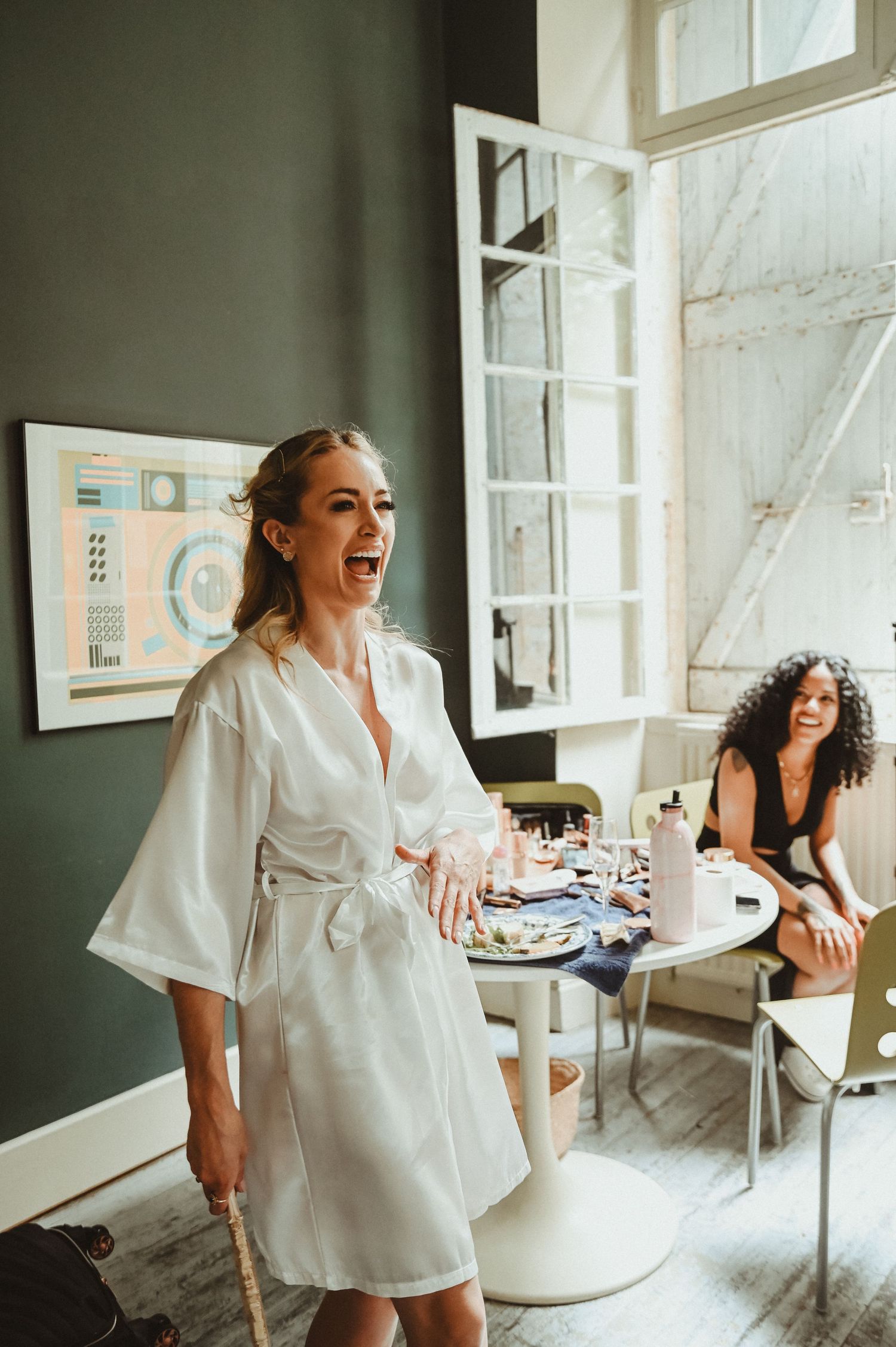 Joyful moment captured during wedding preparations in a bright, modern room.