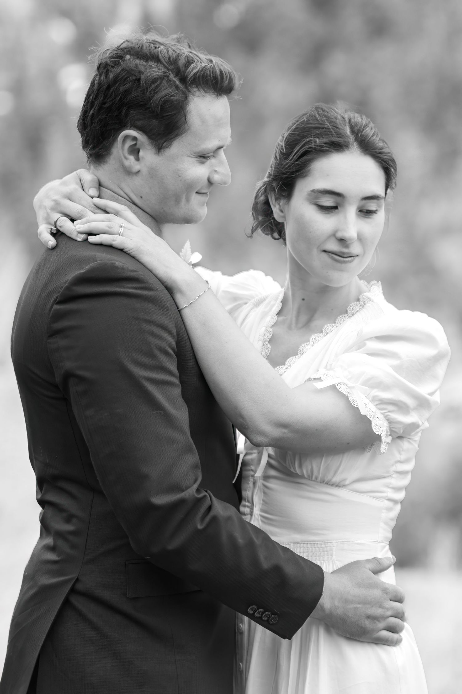 Black and white photo of a bride and groom embracing after their Ouray elopement, smiling softly in elegant wedding attire.