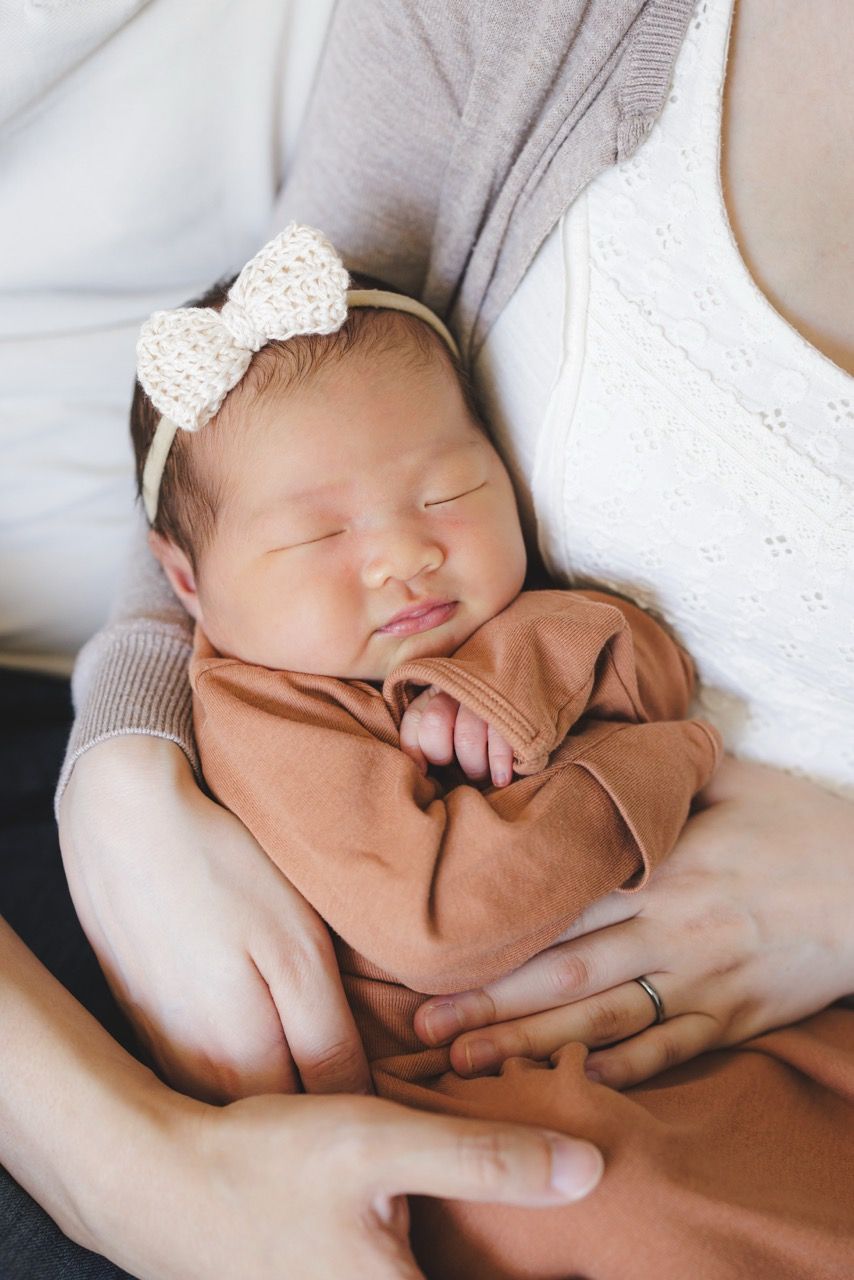 Close up of a newborn baby's face being held by the mother and father during a at home newborn session in Seattle by Tim Neal Photography.