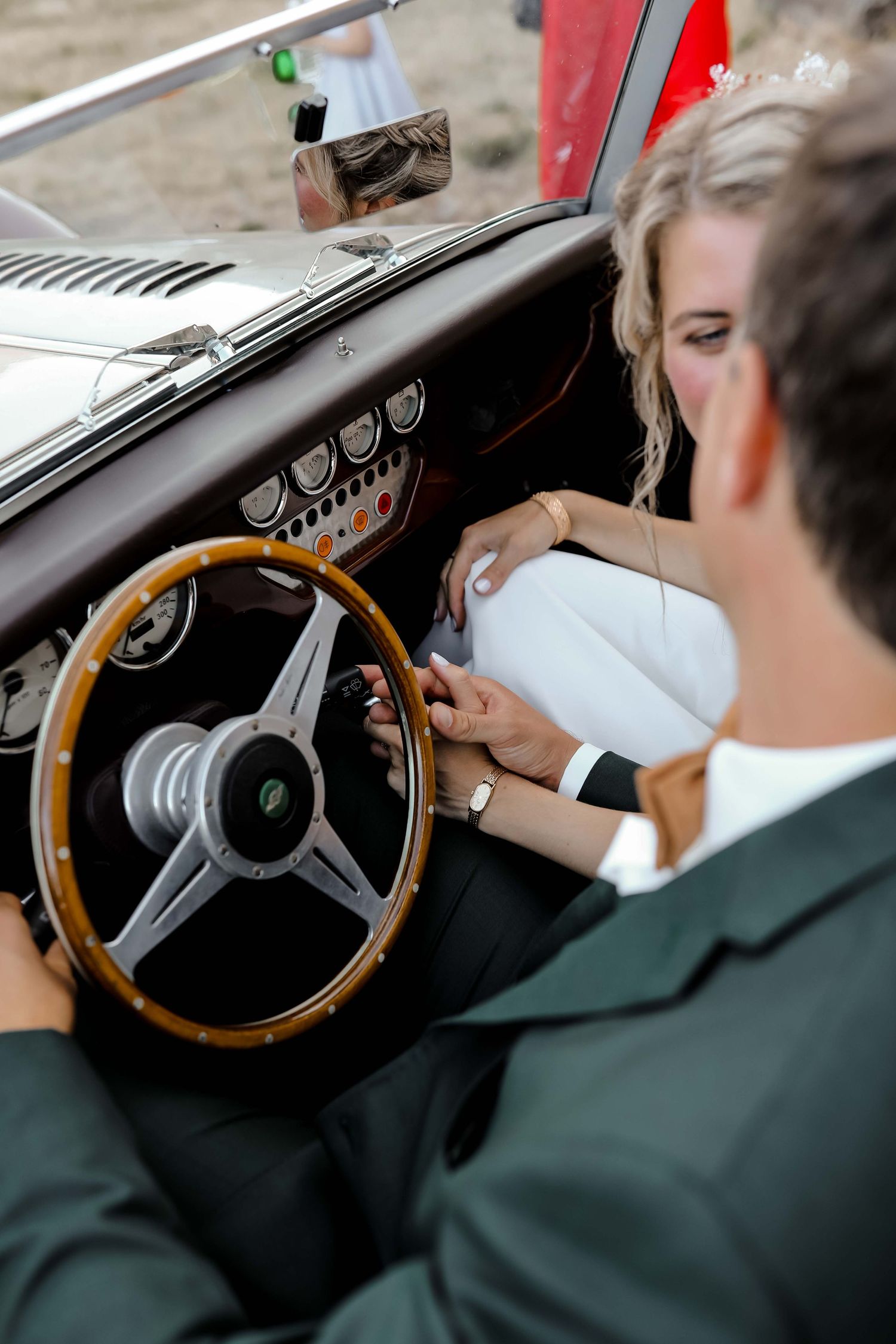 Interior view of classic car dashboard with wooden steering wheel.