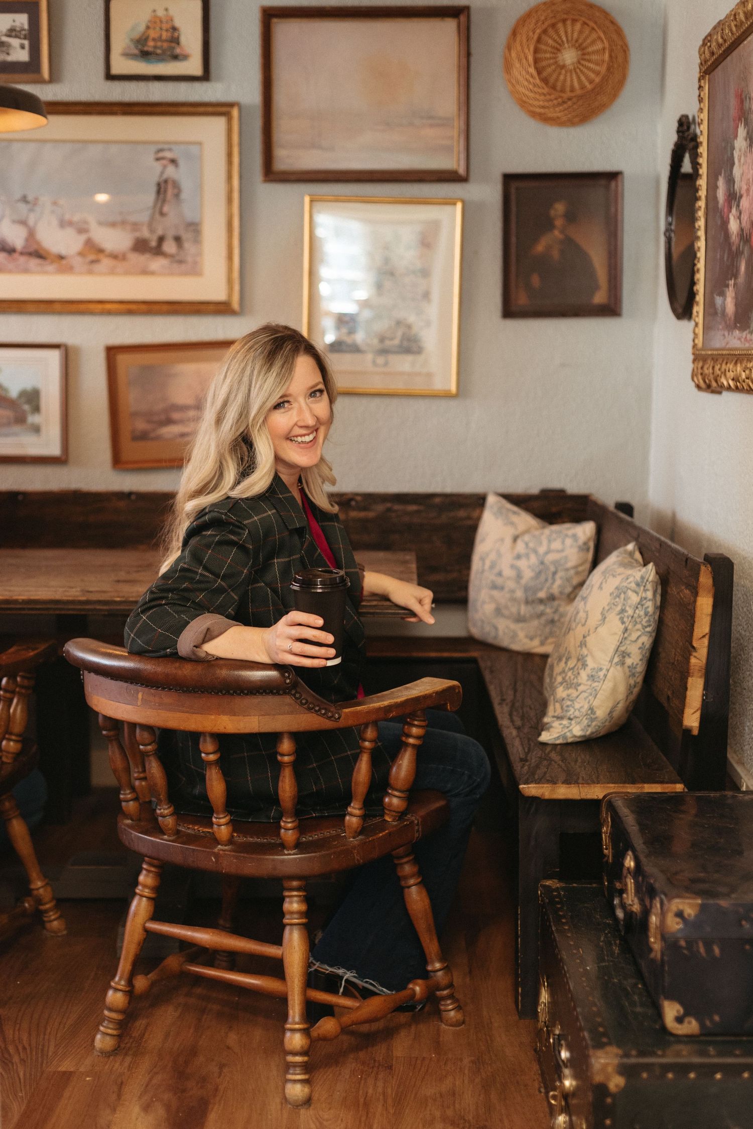 Cozy interior scene with vintage furniture and wall art where someone relaxes in a captain's chair.