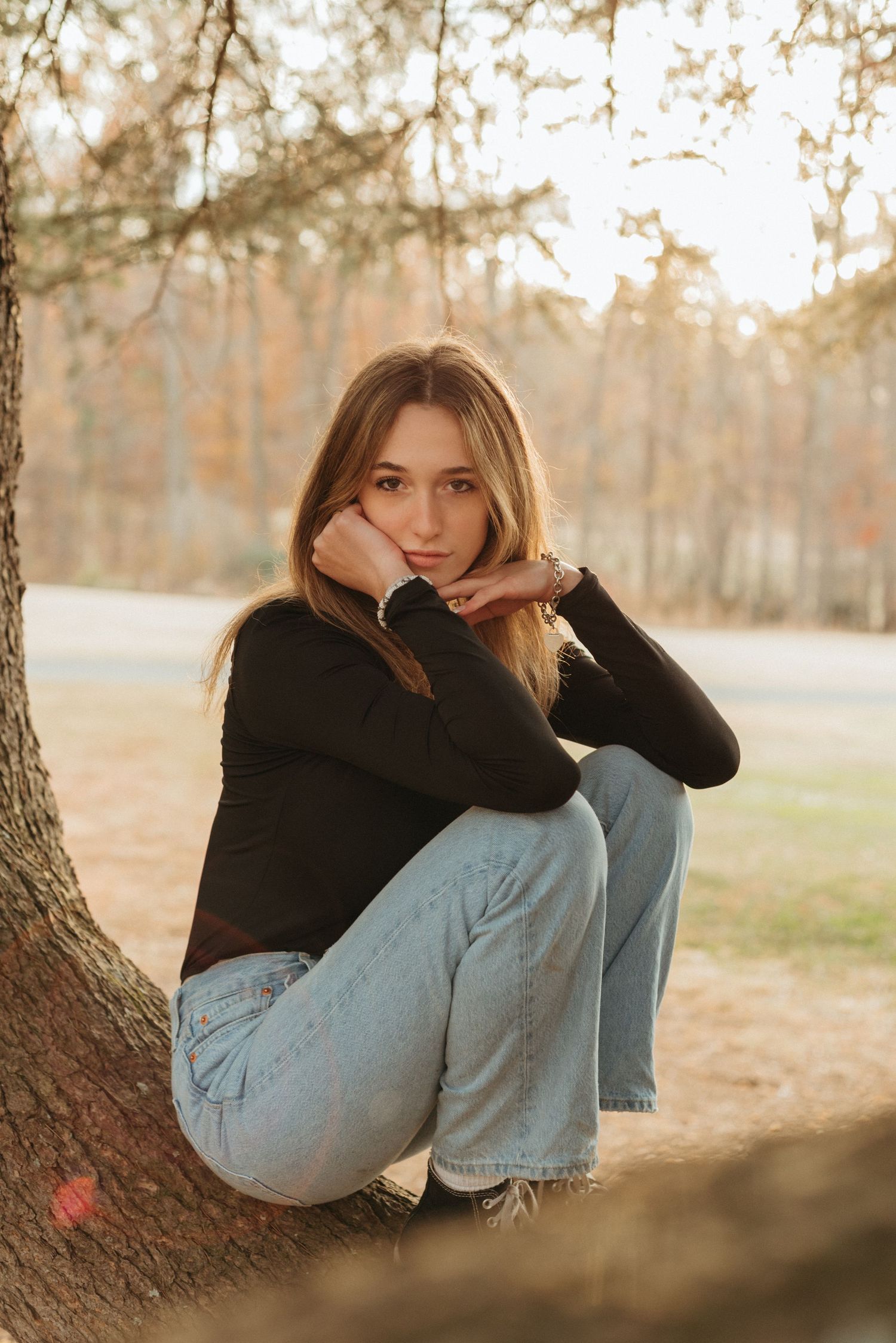 Artistic portrait series in autumn light showing contemplative poses against a tree.