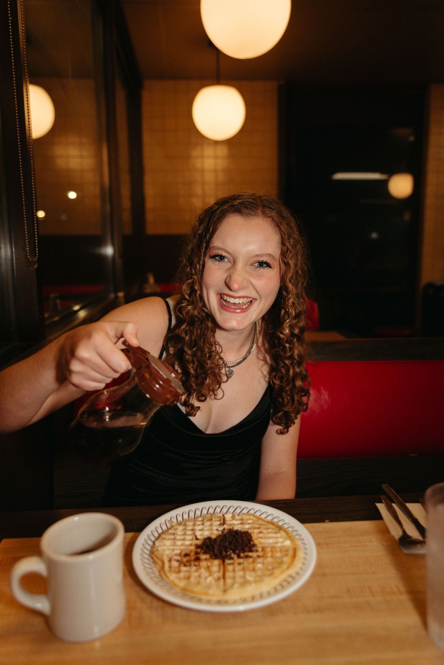 Candid restaurant photos enjoying waffles under warm lighting.