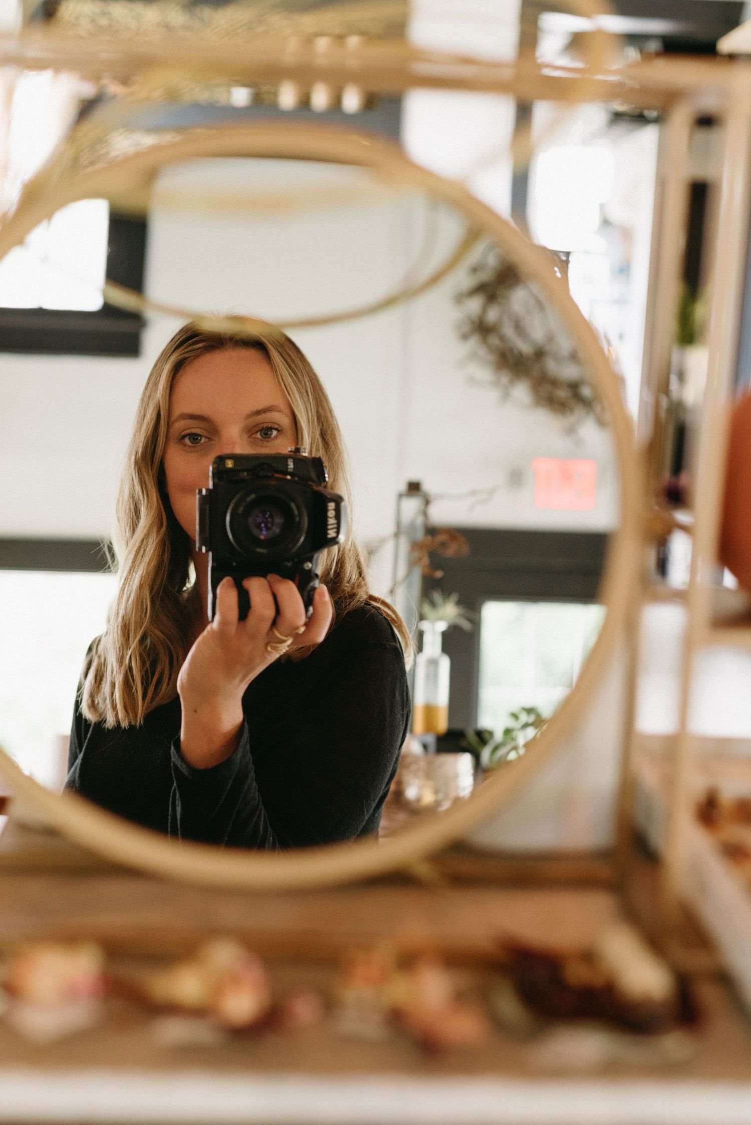 Photographer Rhesa Rogers in a mirror selfie gazing at the lens.