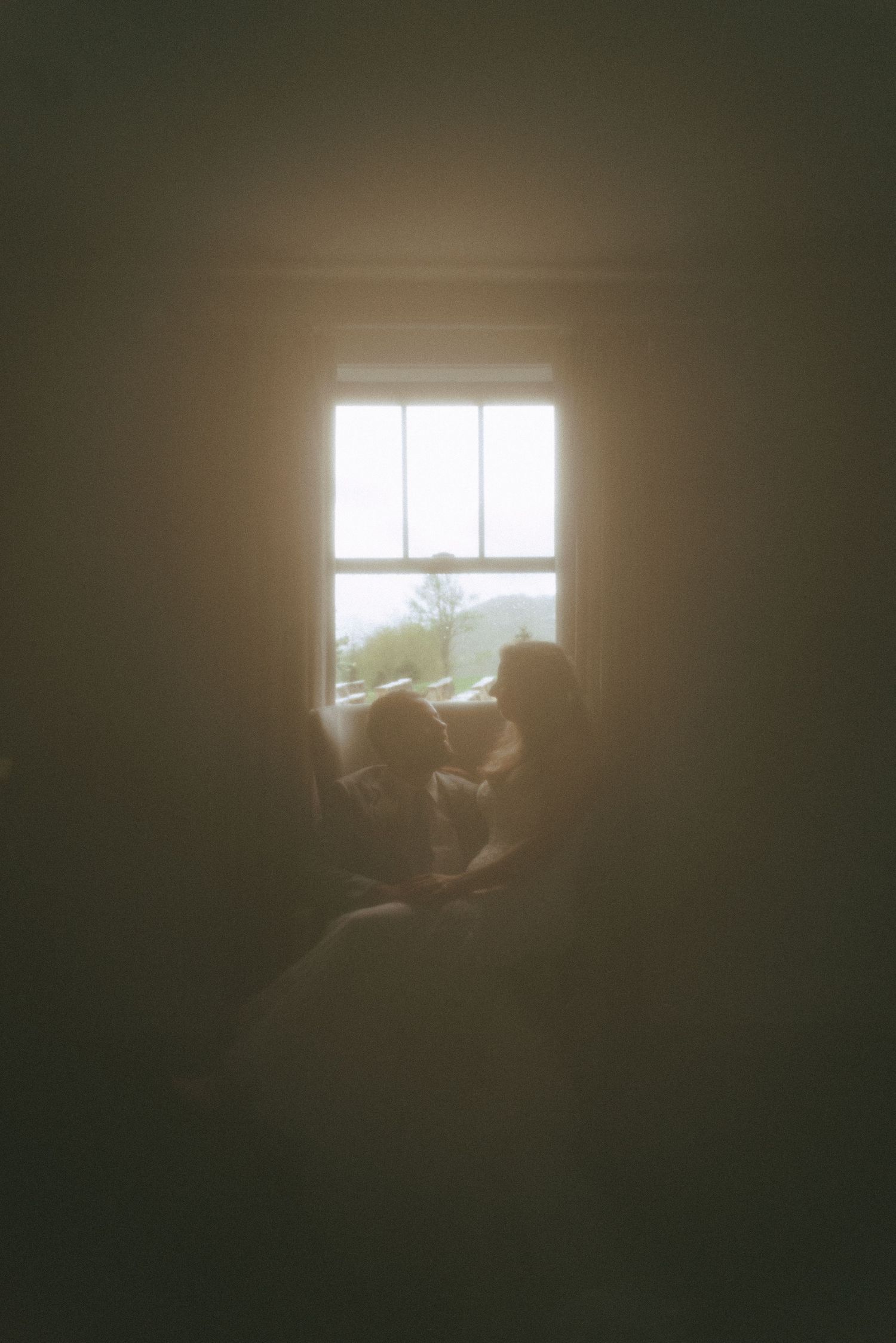 Sunlight streams through a window creating a bright glow in a dark room.