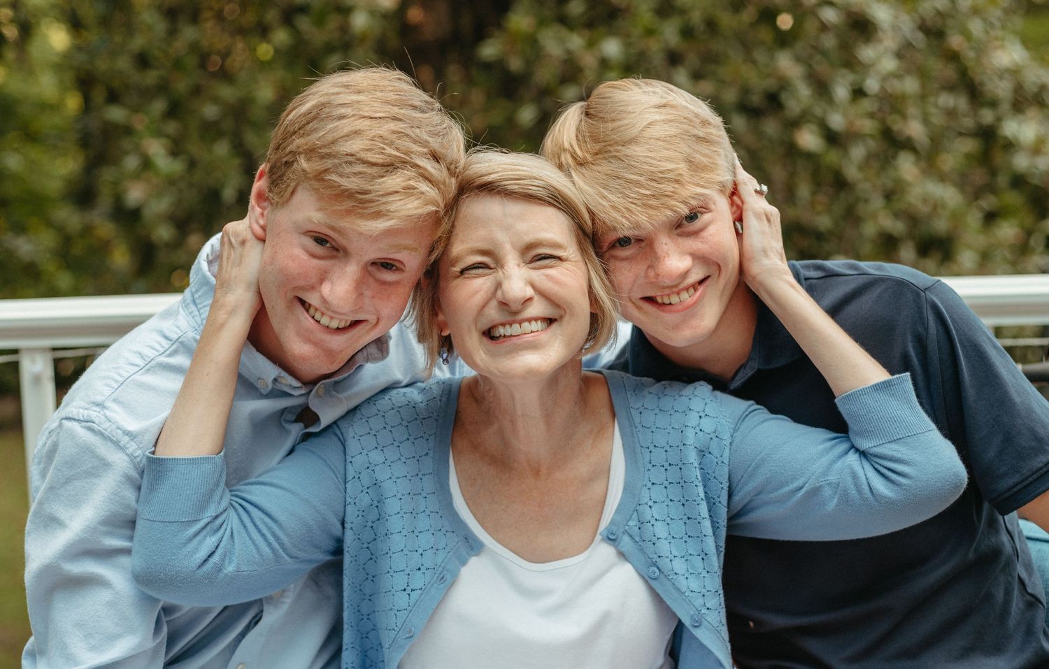 Cheerful family poses for candid portraits outdoors.