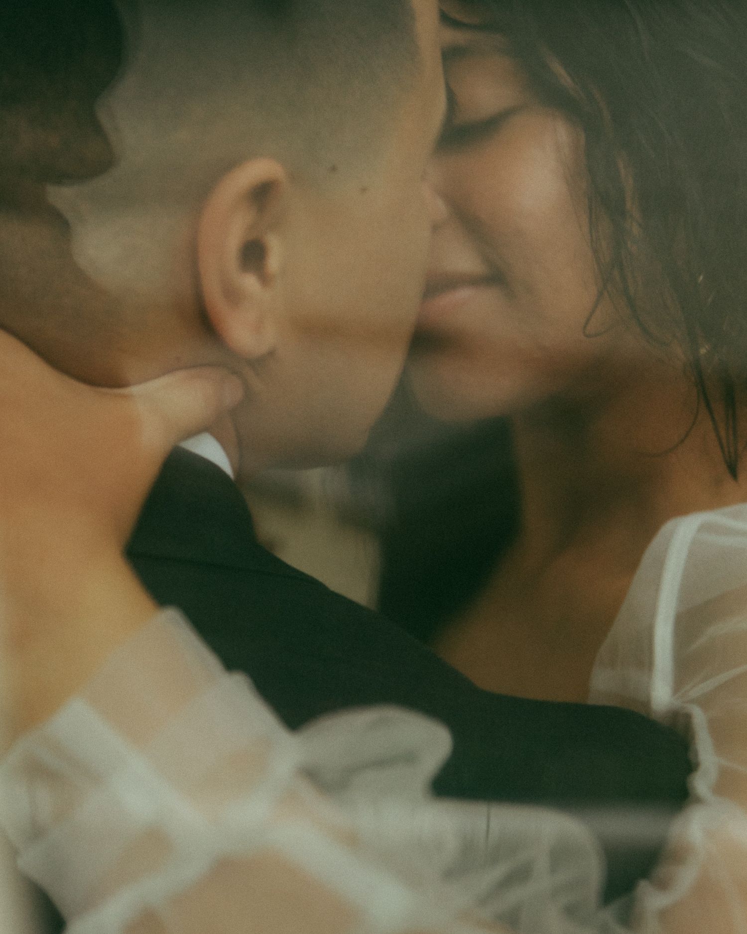 romantic, blurry foreground shot of a couple sharing an intimate kiss, captured by a Poconos, Scranton, NEPA, PA wedding photographer.