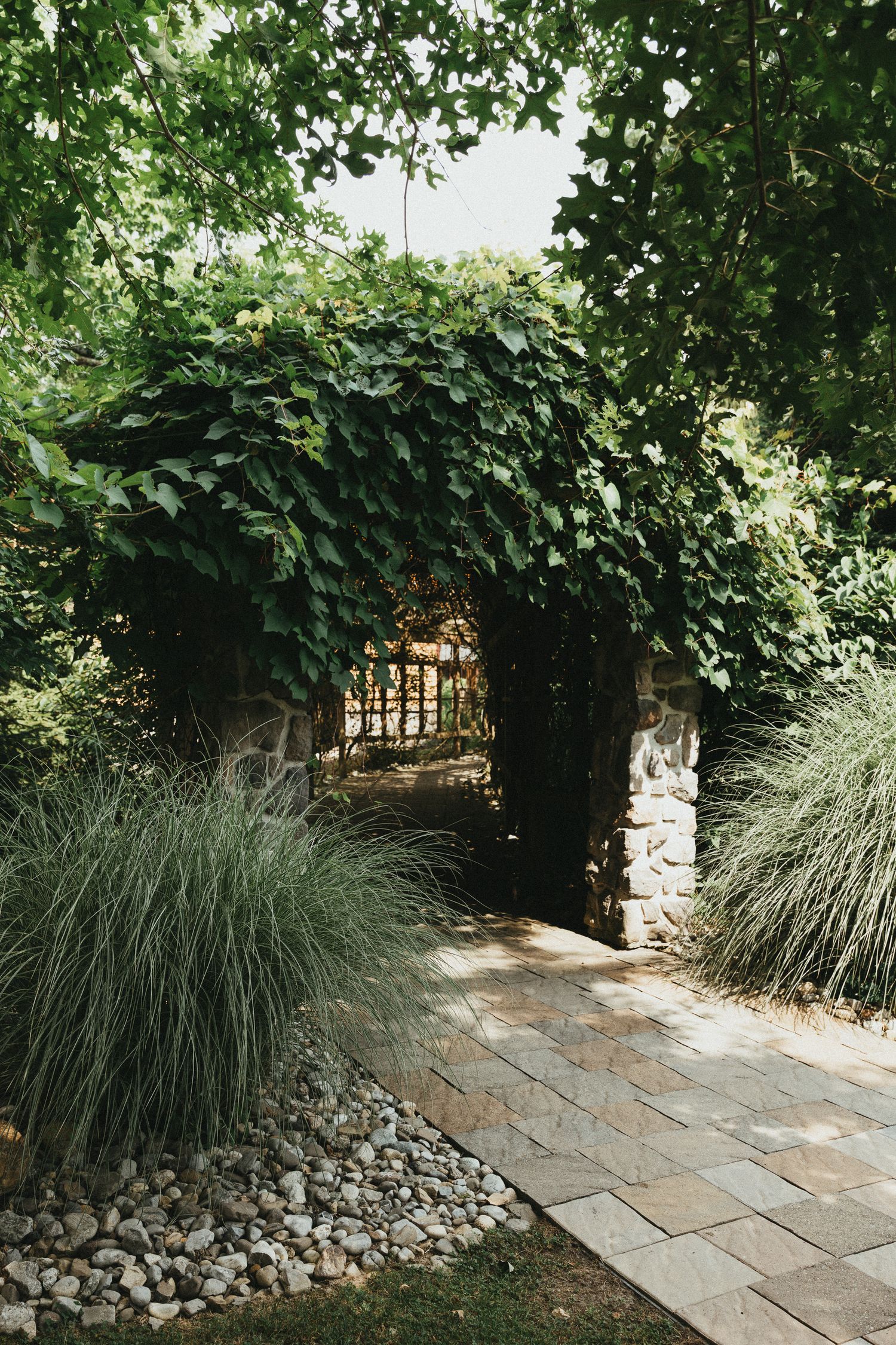 Enchanted garden stone archway and stone path. Professional photography showcasing lush outdoor wedding backdrops in Scranton, Wilkes-Barre,