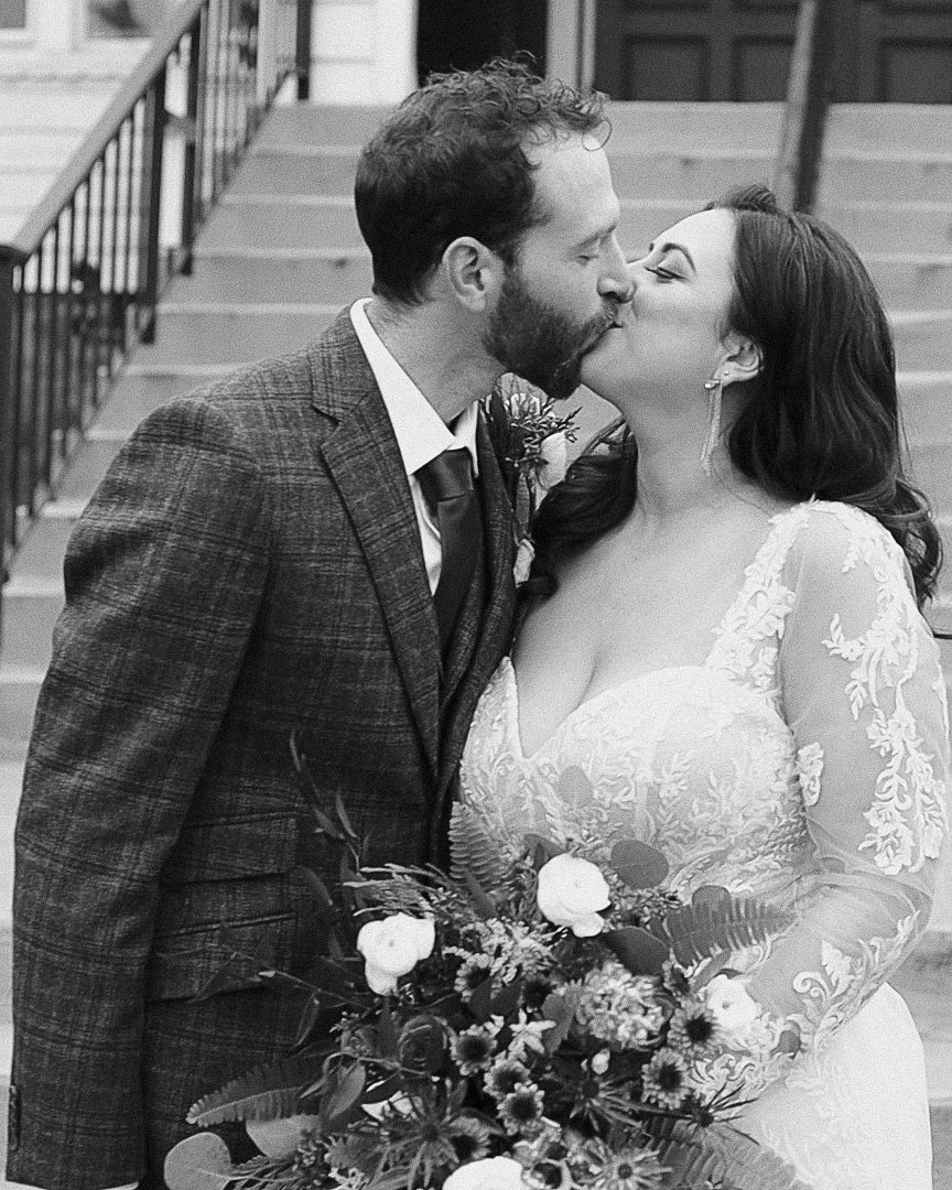 Intimate black and white photography of a bride and groom in a plaid suit kissing, showcasing a nostalgic Poconos elopement style.