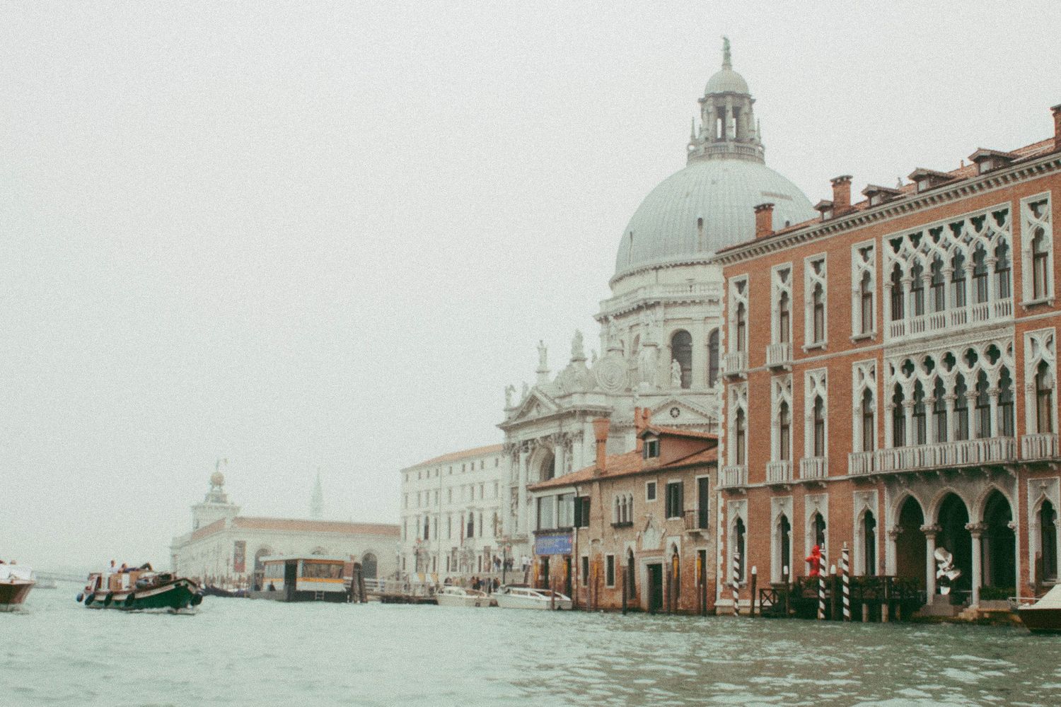 Misty view of Santa Maria della Salute basilica along the Grand Canal in Venice, Italy.