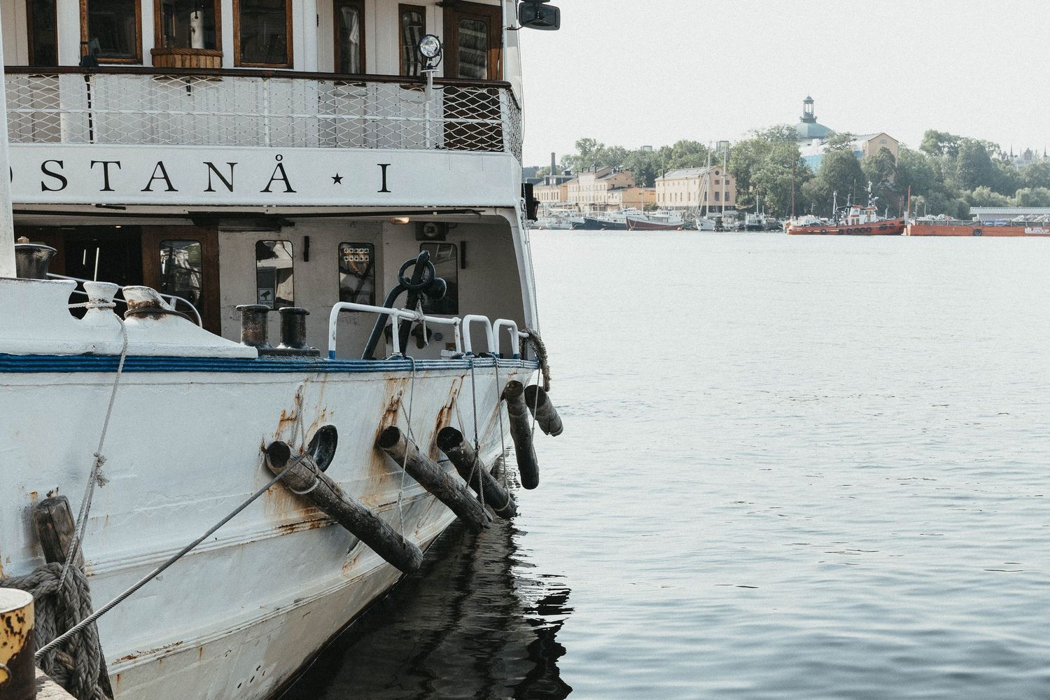 Close-up of a vintage white ferry boat named Stana I docked at a calm harbor.
