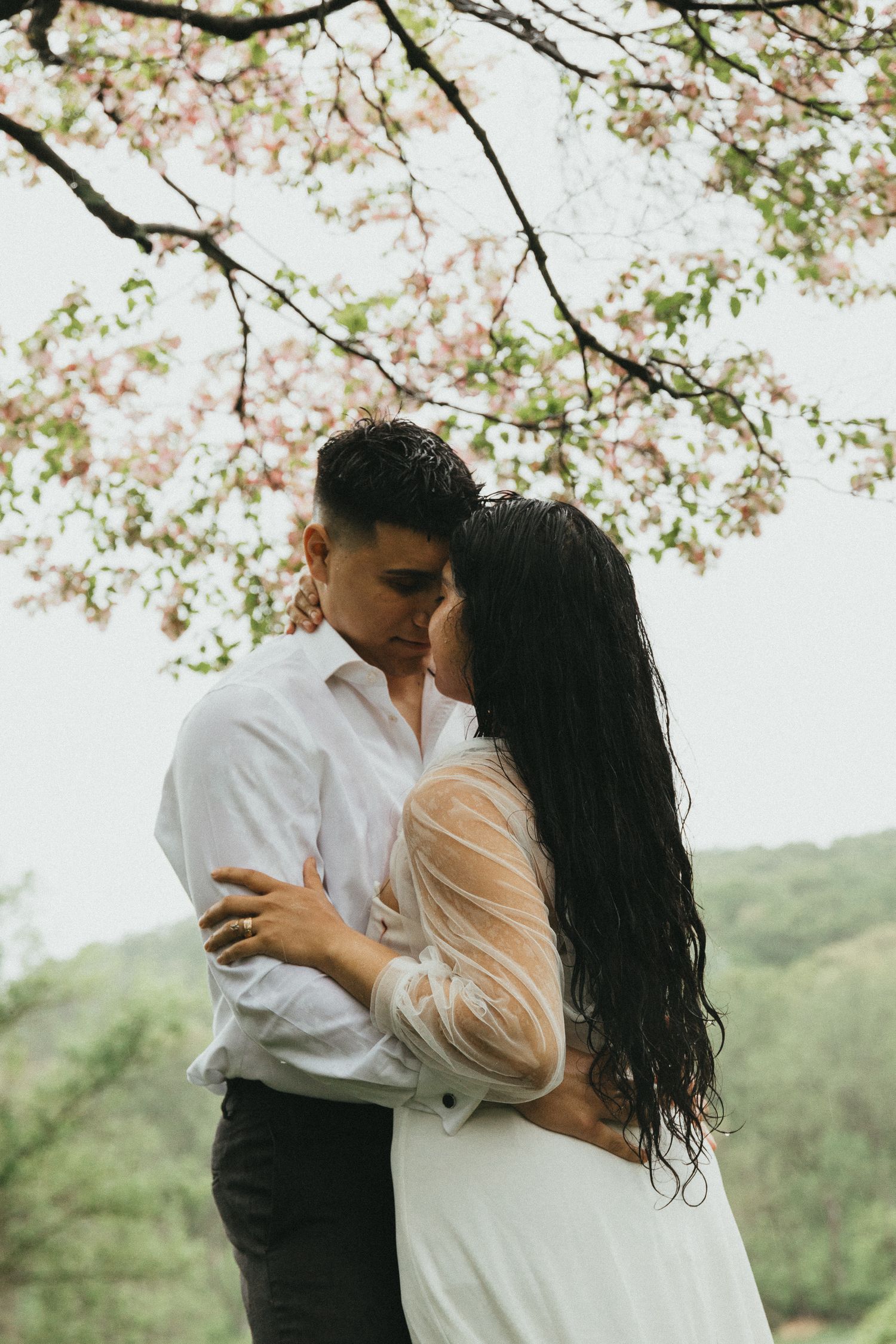Romantic and moody close-up portrait of an eloping couple embracing in the rain with wet hair, captured by a Poconos wedding photographer.