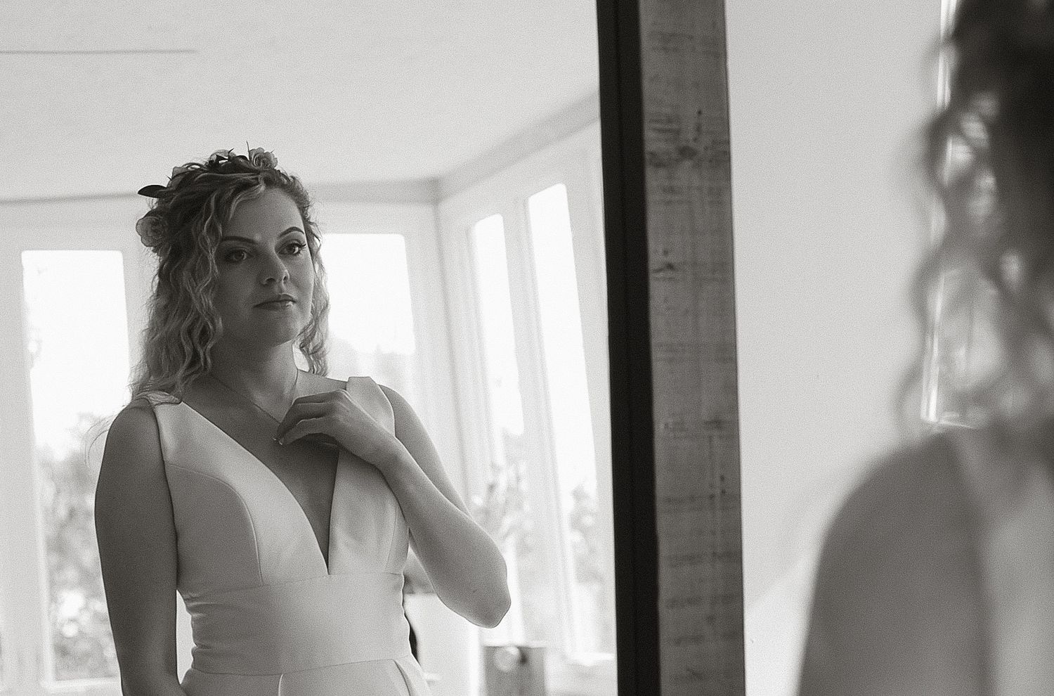 A black and white bridal portrait of a bride looking in a mirror during a getting-ready session, captured by a Lehigh Valley wedding photogr