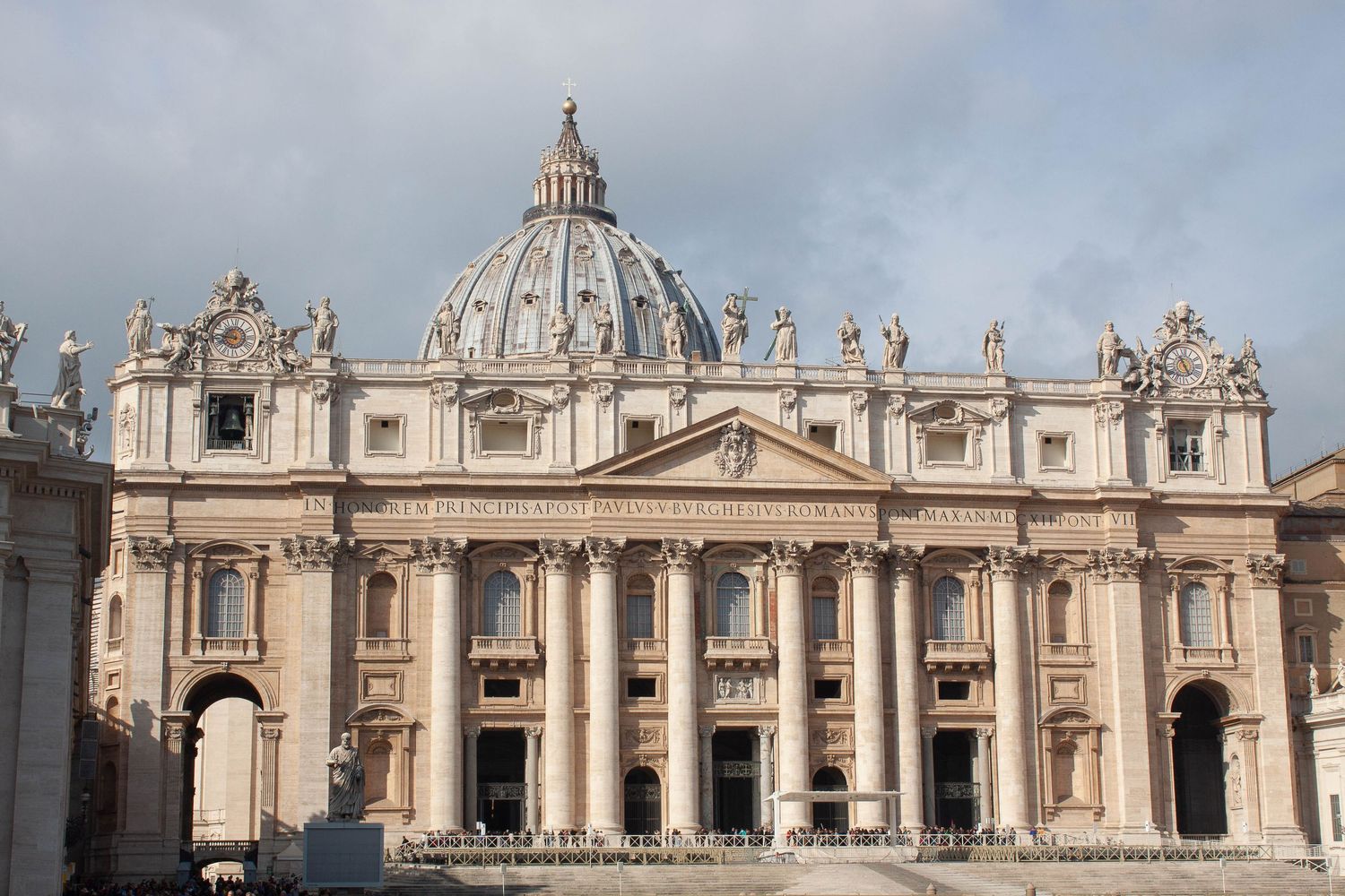 St. Peter's Basilica facade with ornate Baroque architecture and statues in Vatican City, Rome.