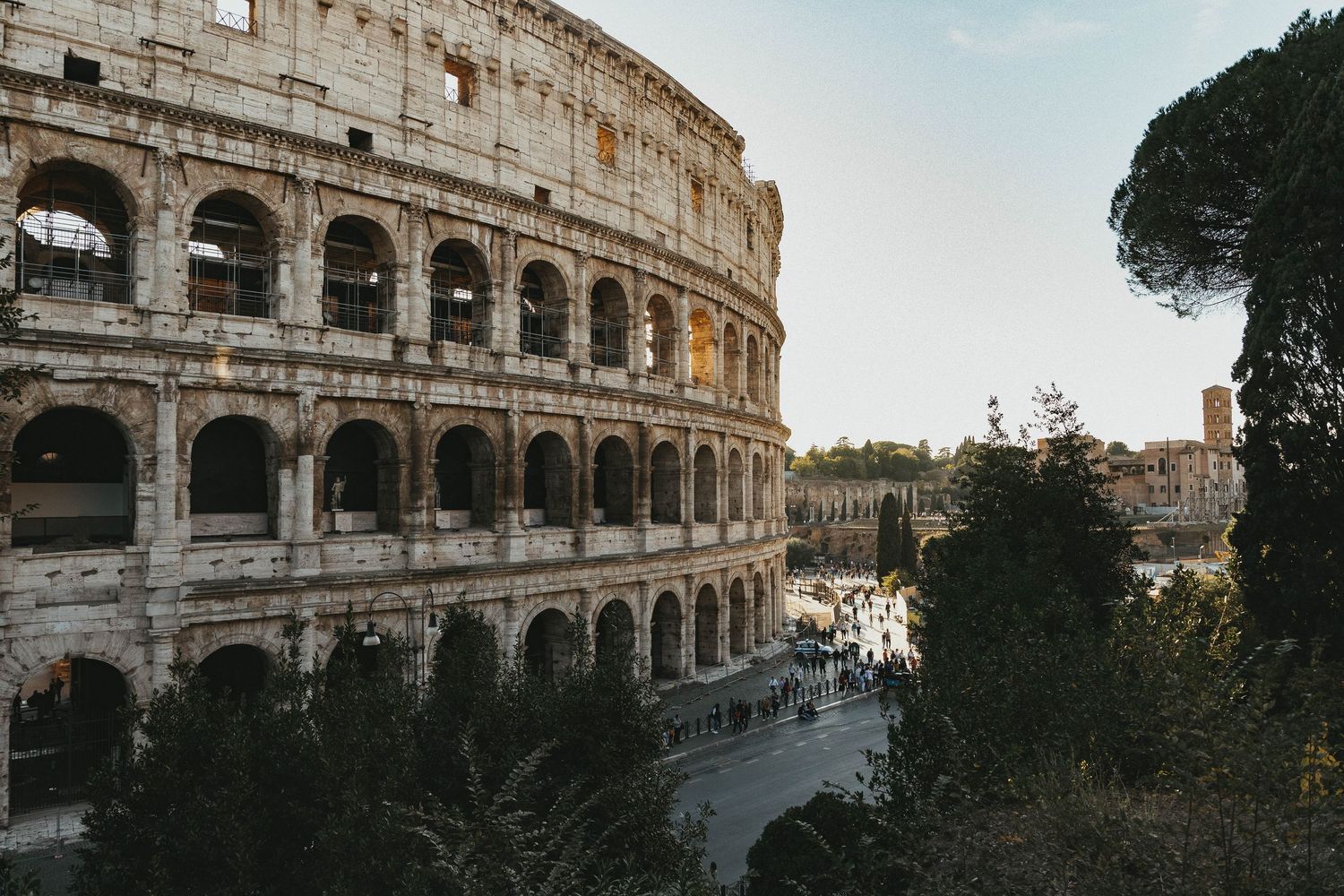 Aerial view of the ancient Roman Colosseum surrounded by trees in Rome, Italy.