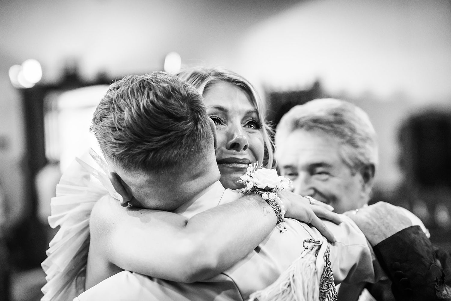 Black and white candid shots of wedding celebration embraces.