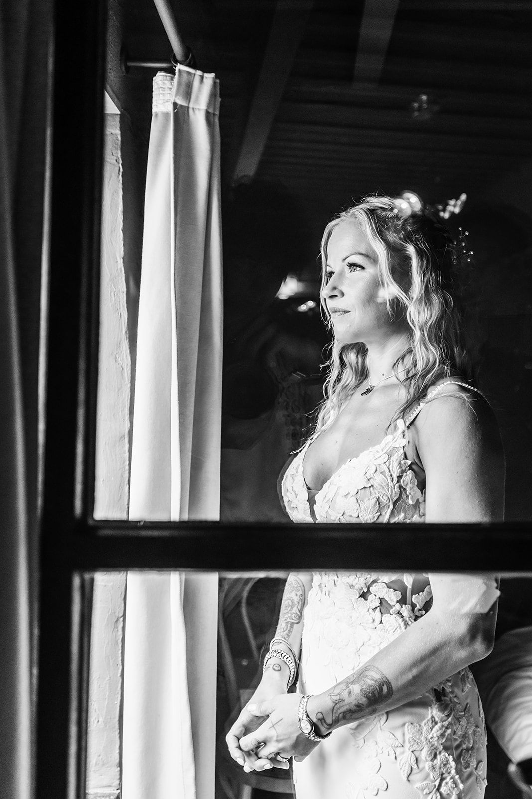 Dramatic black and white bridal portraits through window reflections.