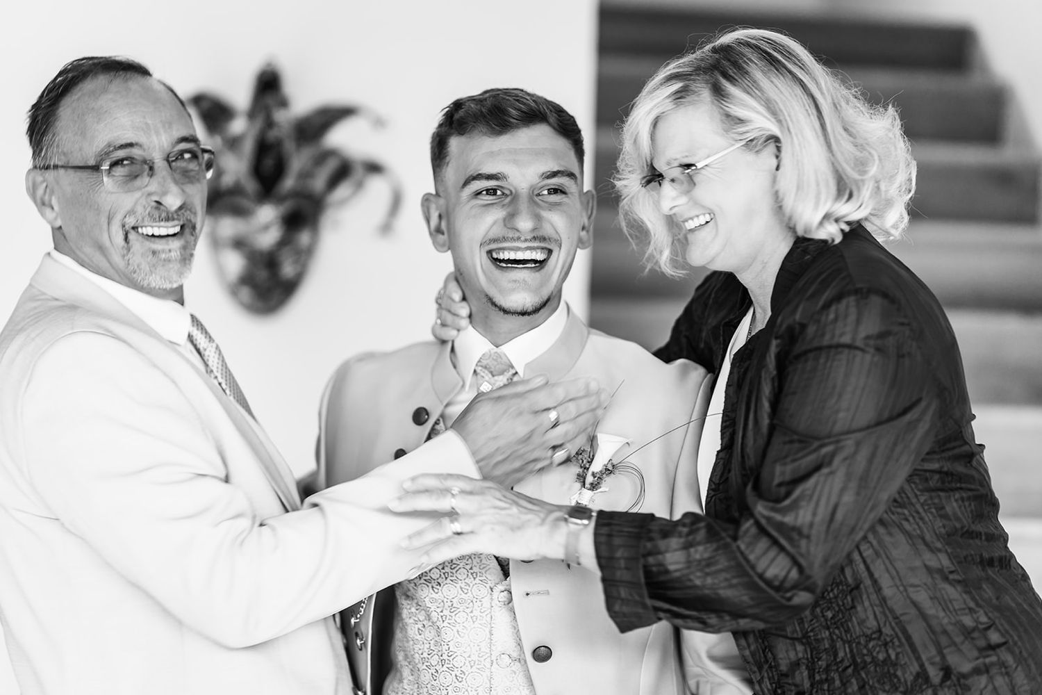 Portrait de famille émouvant en noir et blanc, complicité entre générations lors d'une réception de mariage.