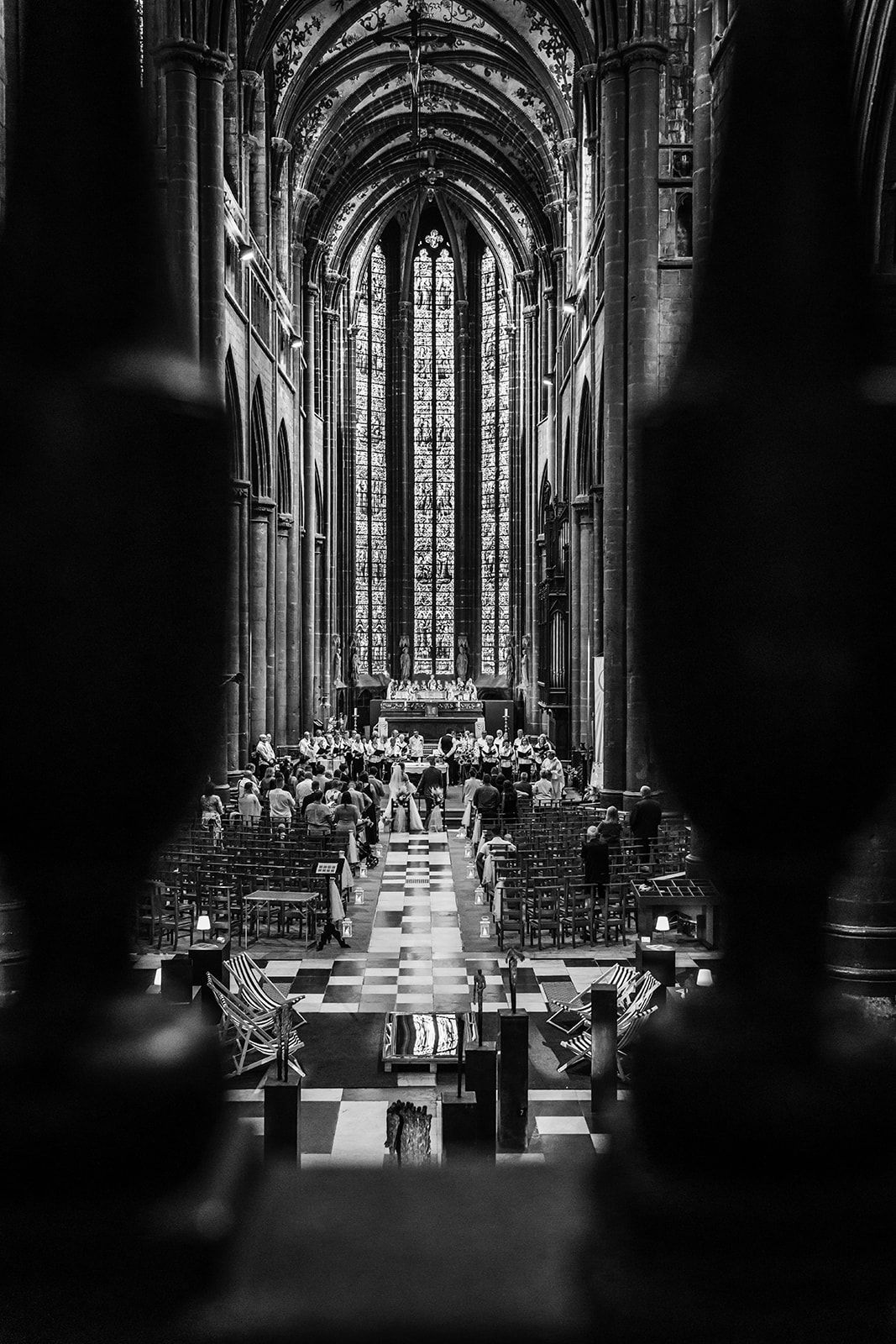 Dramatic black and white photo of gothic cathedral interior set for wedding ceremony.