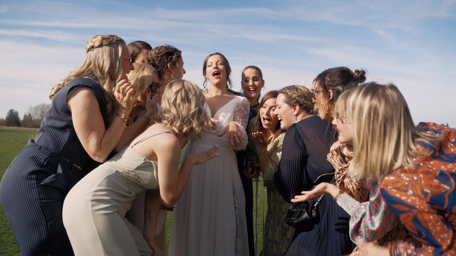 Moment de complicité entre la mariée et ses amies, rires et émotions lors d'un mariage festif en Belgique.
