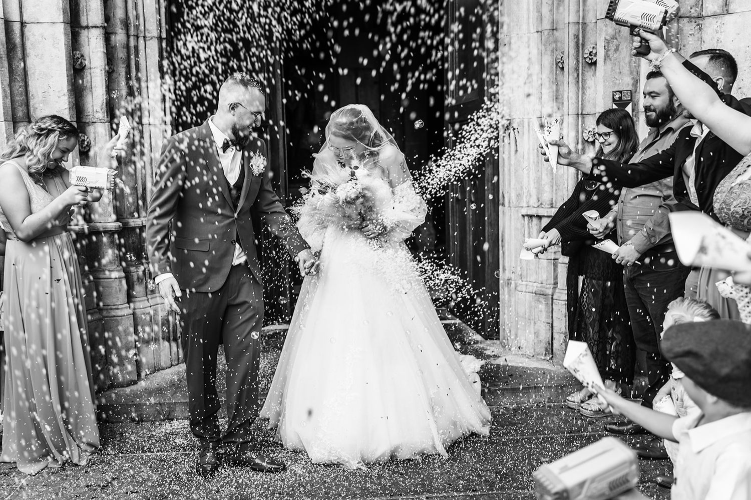 Wedding party celebrates with confetti and joyful moments outside a church.