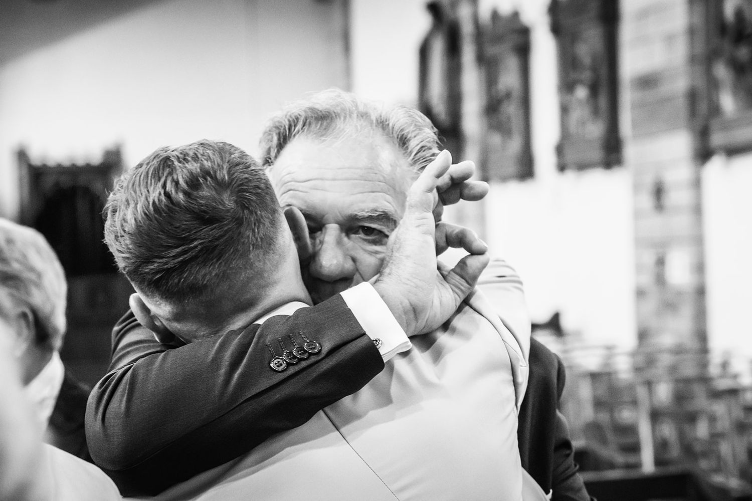 An emotional black and white moment captured during a wedding celebration.
