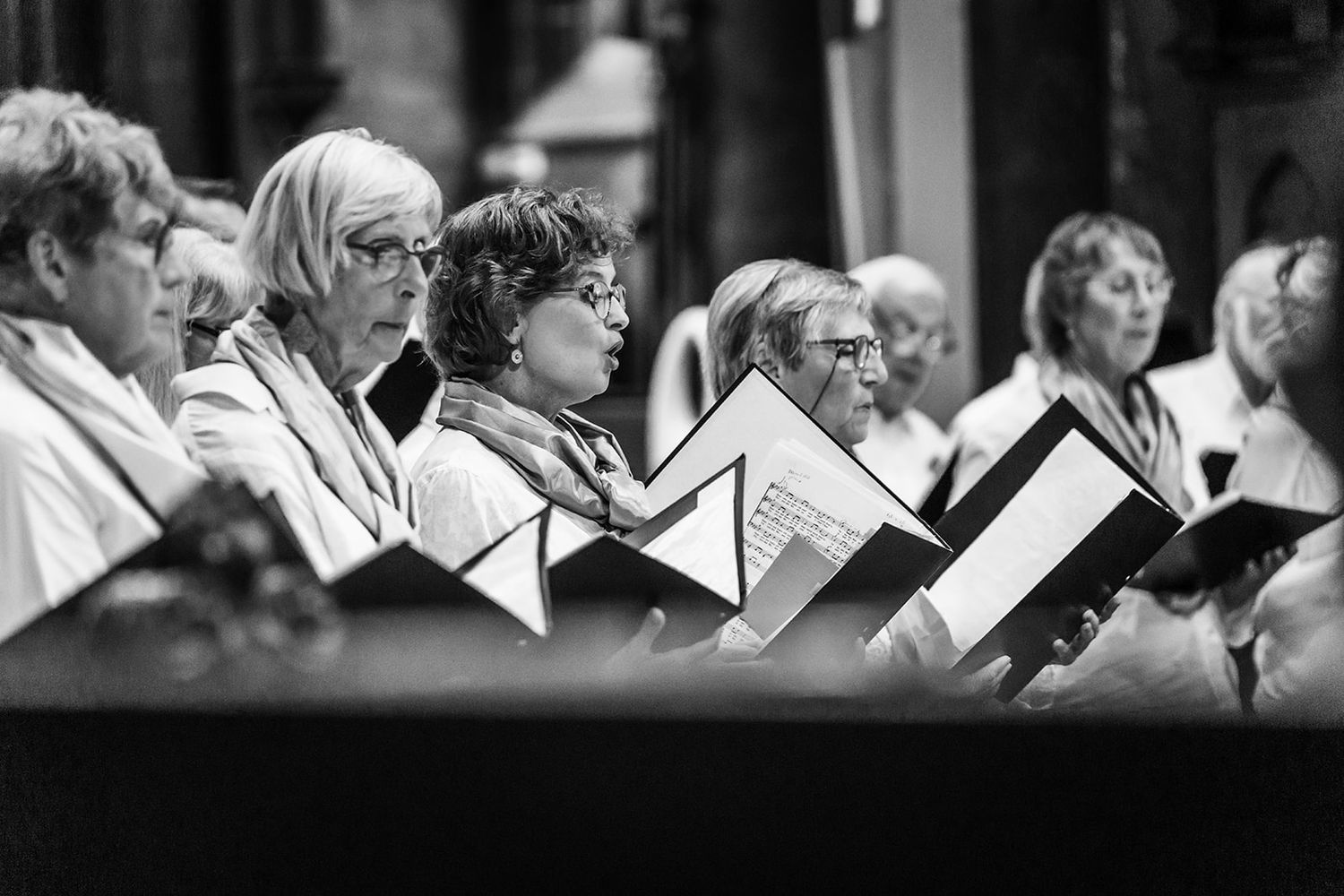 Choir members perform in black and white formal attire during a church service.