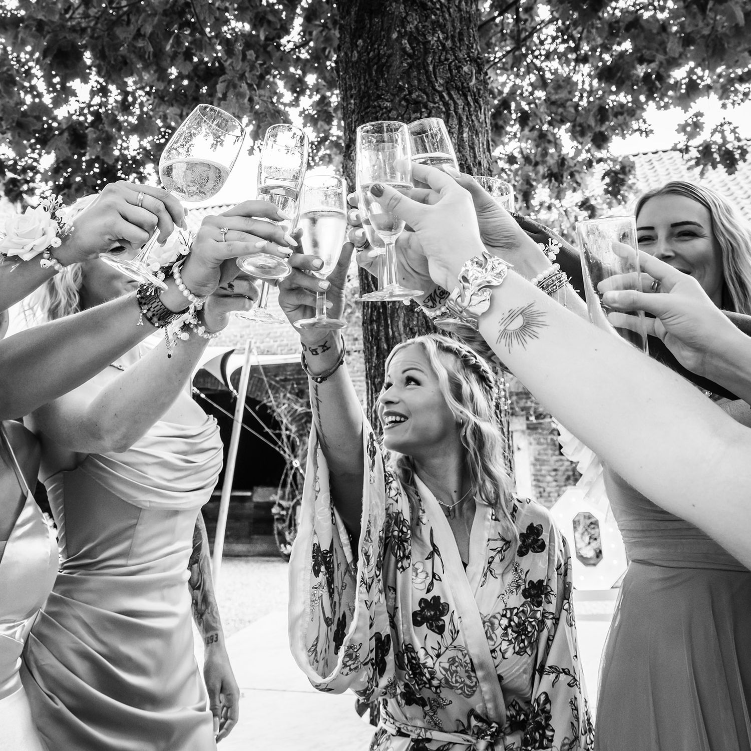 Wedding guests dance and celebrate in black and white candid shots.