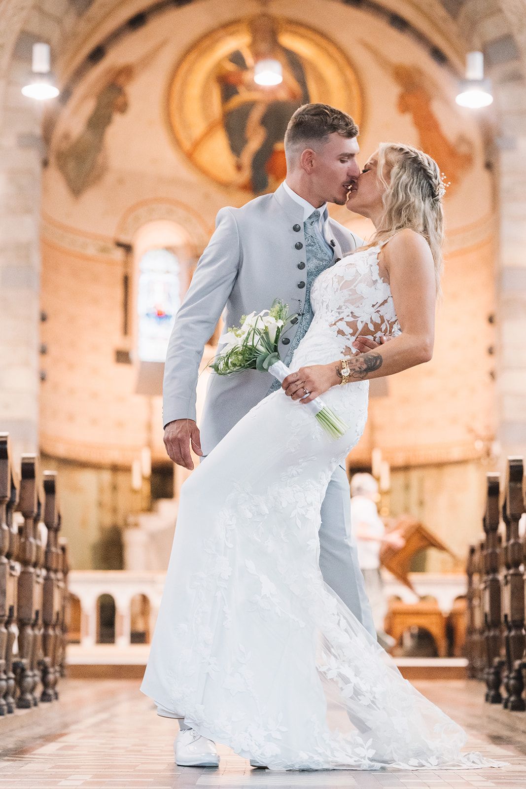 Romantic wedding couple dances in an elegant church with warm lighting.