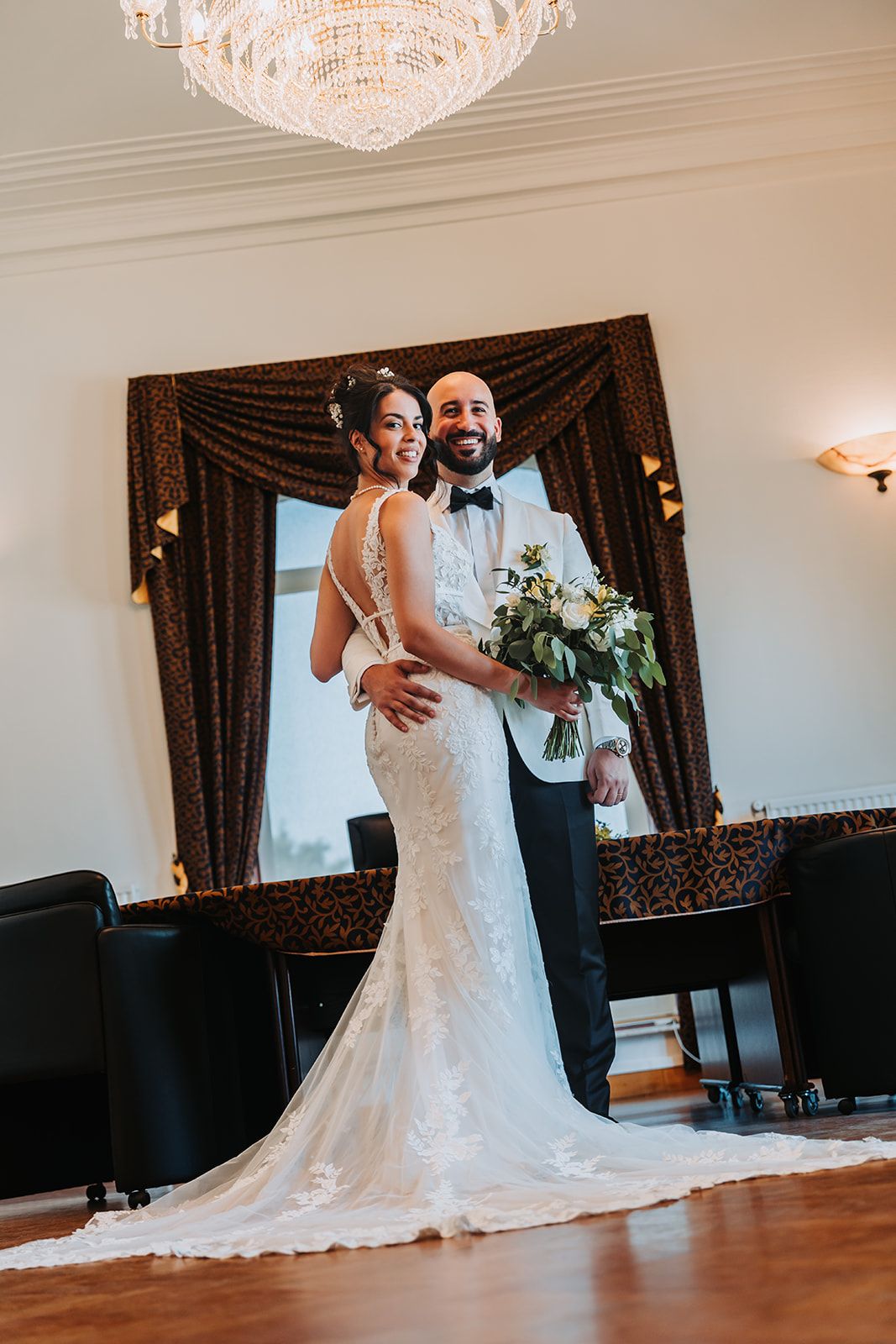 Elegant wedding portrait showing the back detail of a fitted lace gown.