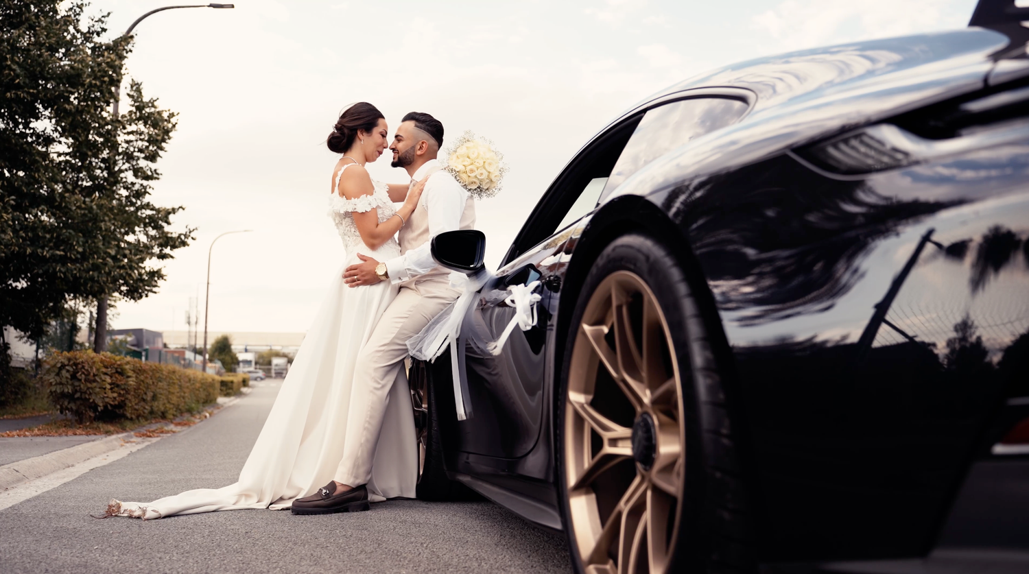 Séance photo de couple moderne avec voiture de prestige, photographe mariage Namur, style cinématographique et élégant.