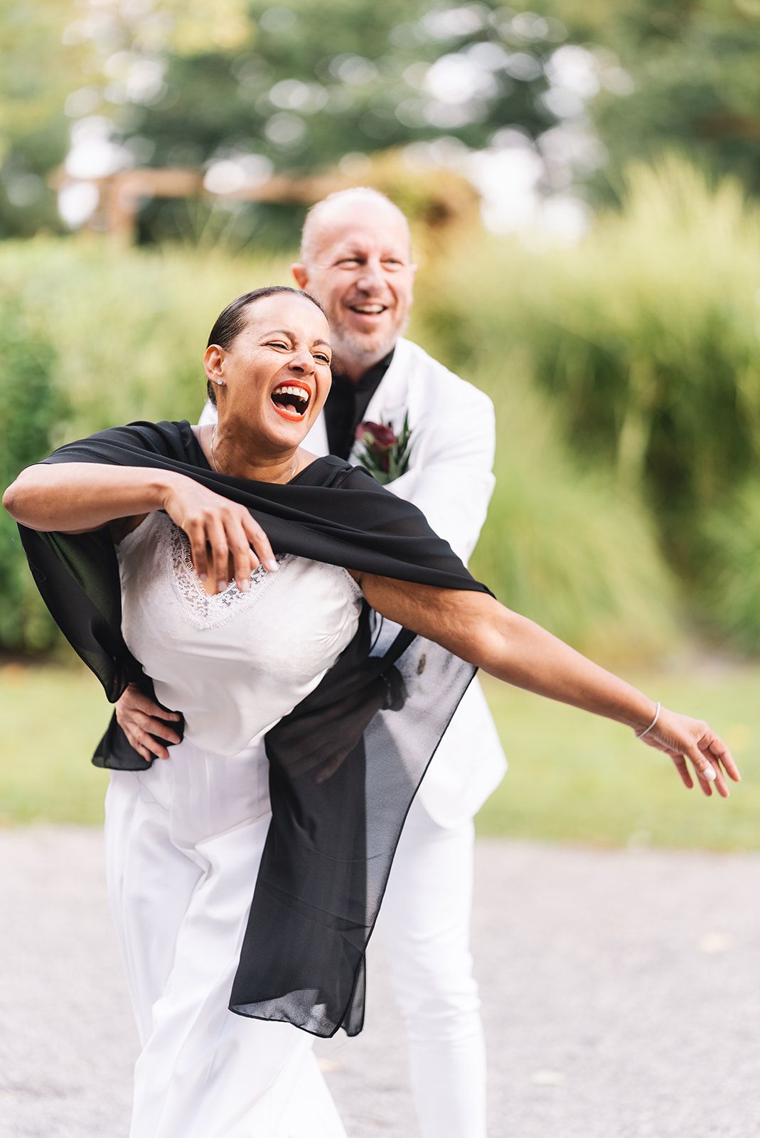 A joyful couple in wedding attire embraces and laughs together in a series of candid outdoor photos.