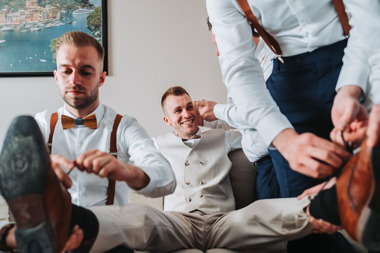 Wedding party members in formal attire prepare together indoors.