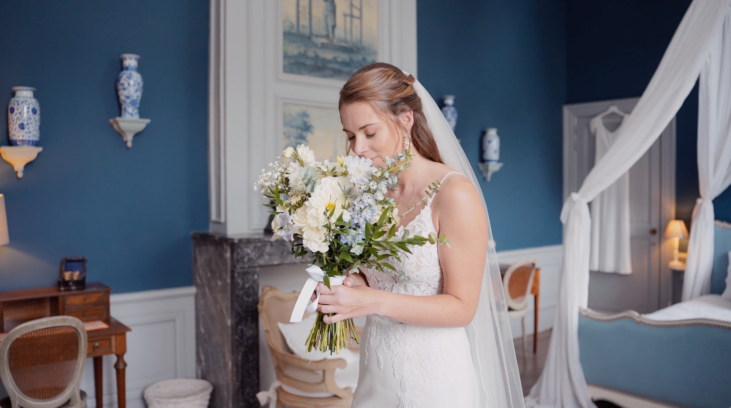 Portrait élégant de la mariée avec son bouquet de fleurs blanches, intérieur de prestige au Château Bayard.