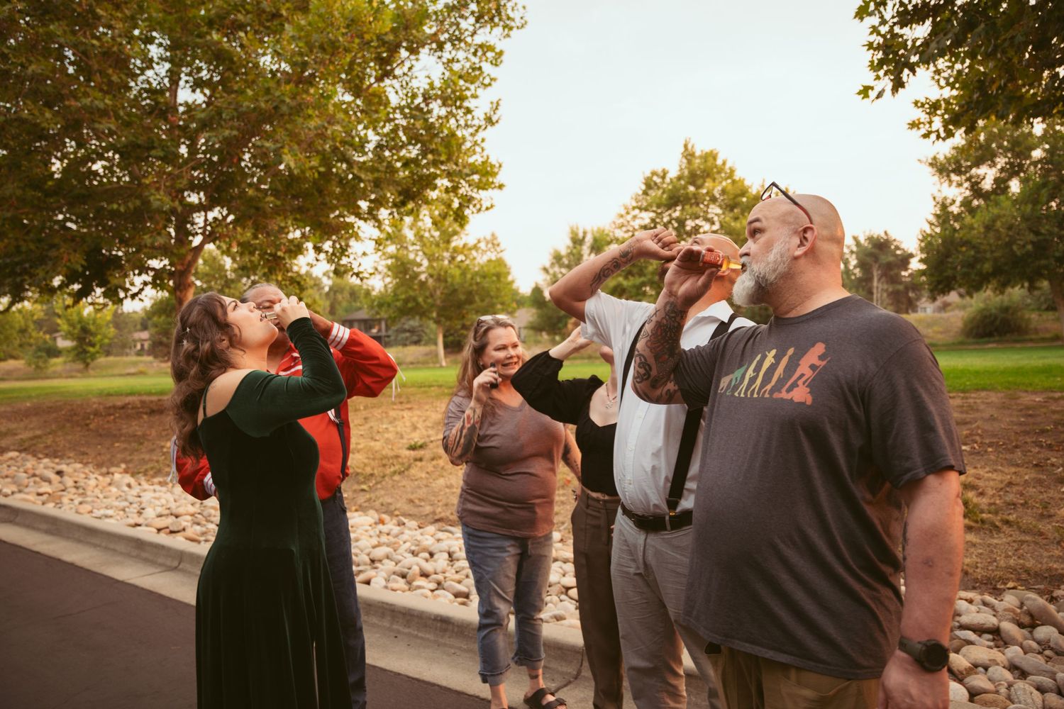 Friends taking drinks together outdoors during a casual gathering.